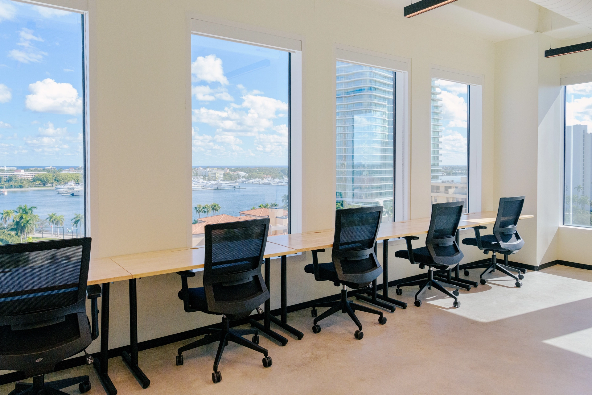 A spacious office workspace with multiple desks and stunning city views in West Palm Beach.