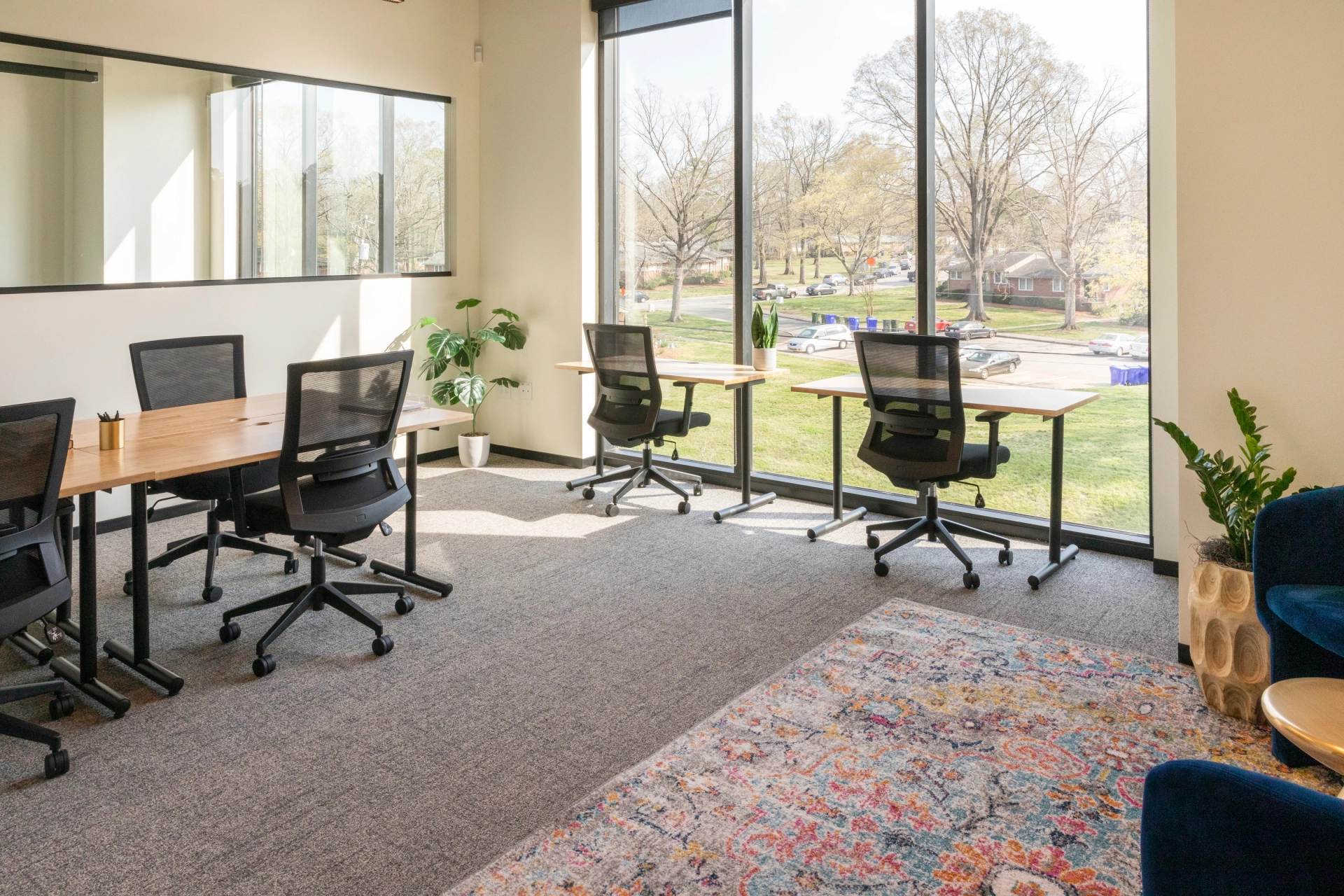 An office meeting room in Chapel Hill with desks and chairs facing a large window.