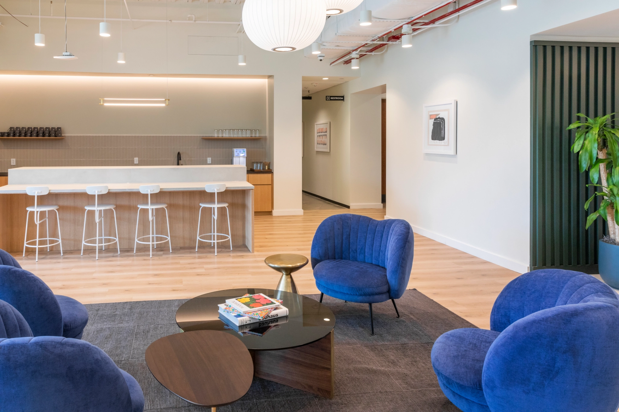 Un espace de travail de bureau avec des chaises bleues et une table basse.