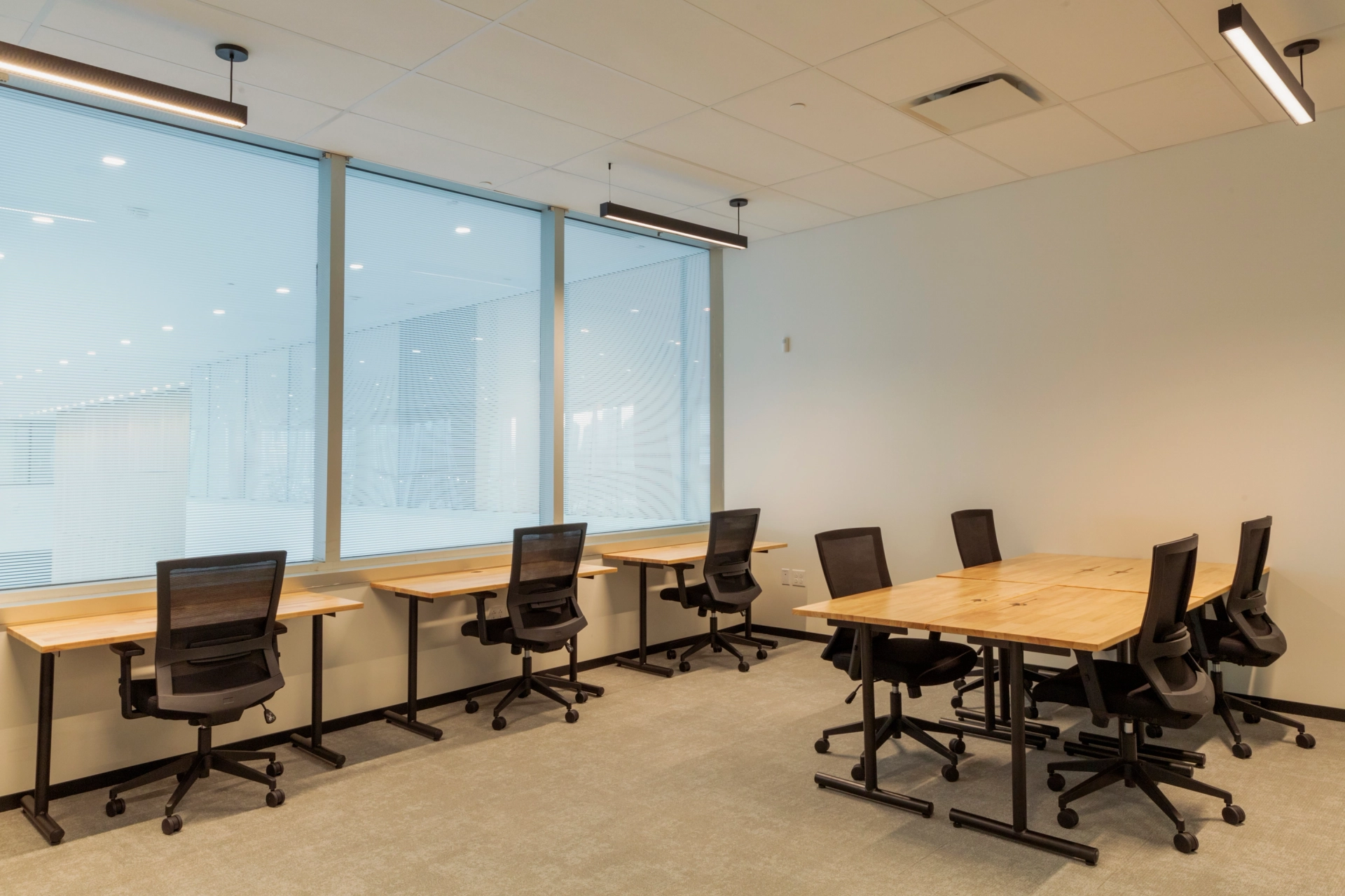 une salle de réunion avec plusieurs bureaux et chaises.