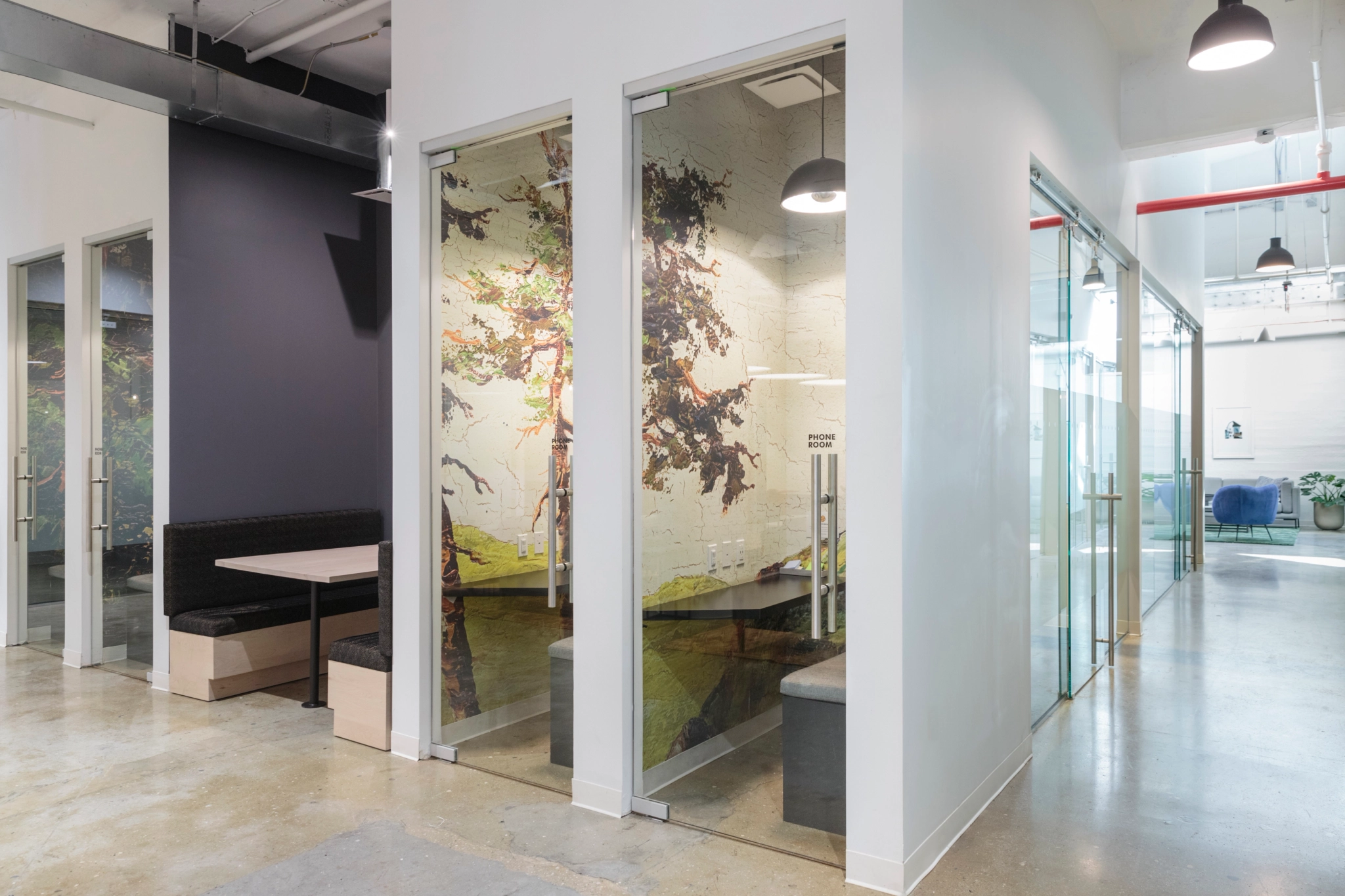 An office with glass walls and a bench, suitable for coworking or meetings.