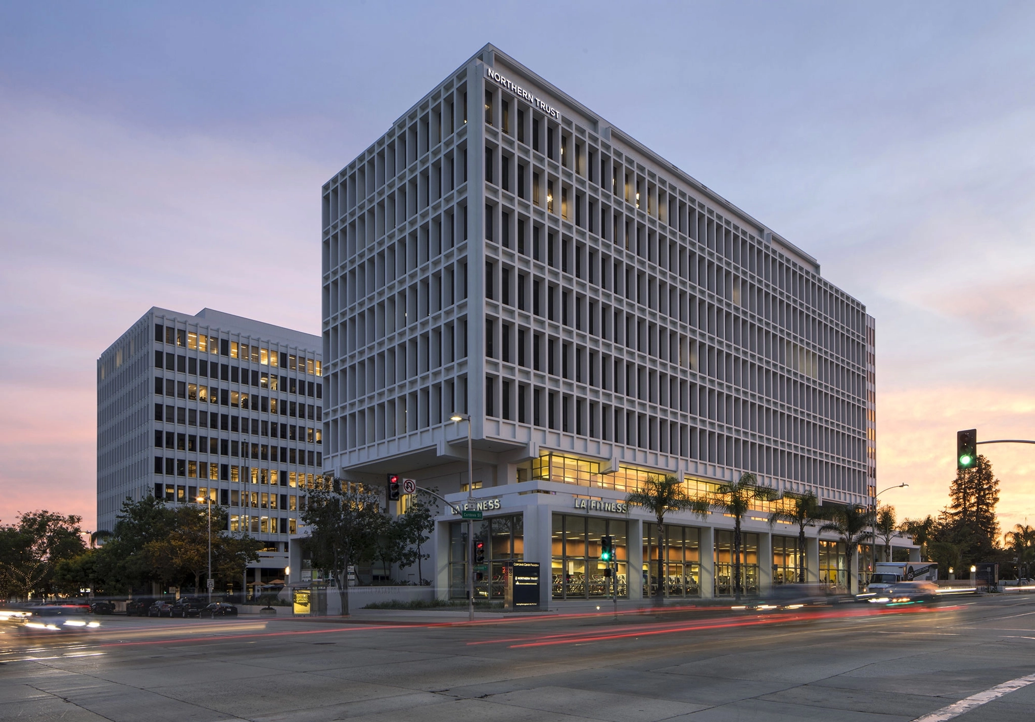 An office building in Pasadena, featuring a coworking space with meeting rooms, against the backdrop of a dusk-lit street.