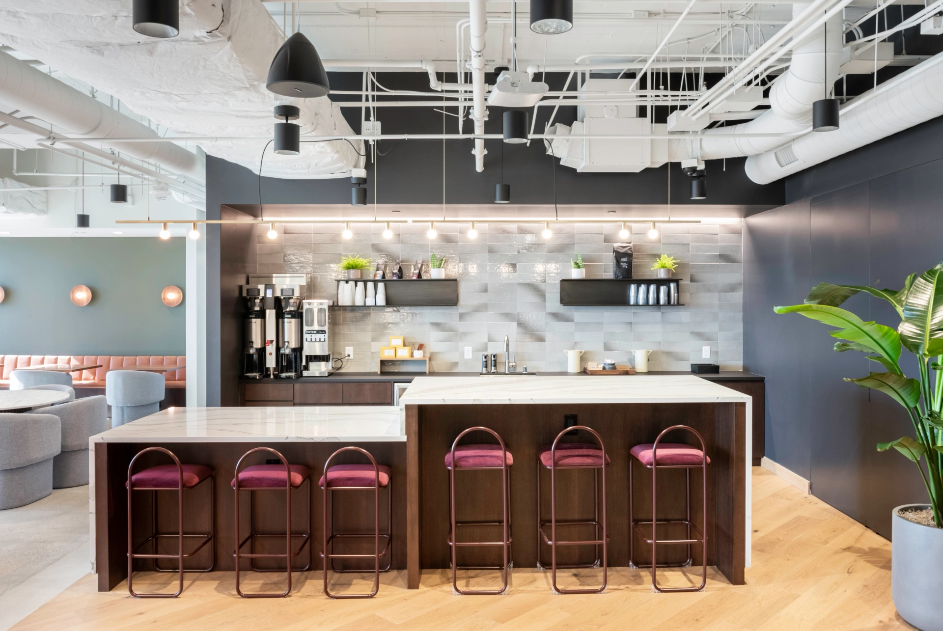 A Pasadena coworking space featuring a meeting room with a kitchen and bar stools.