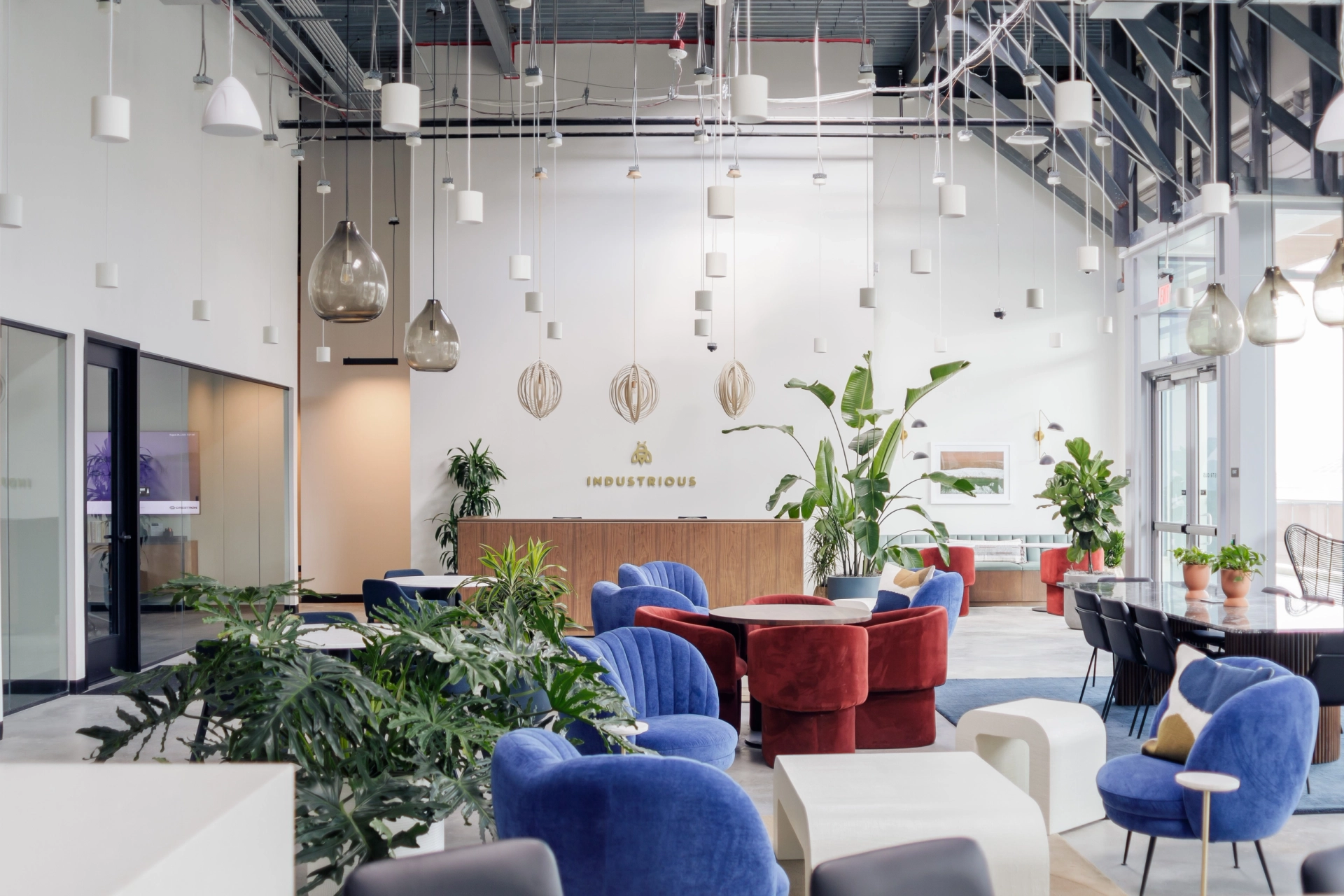 A modern coworking office in Aventura with blue chairs and plants.