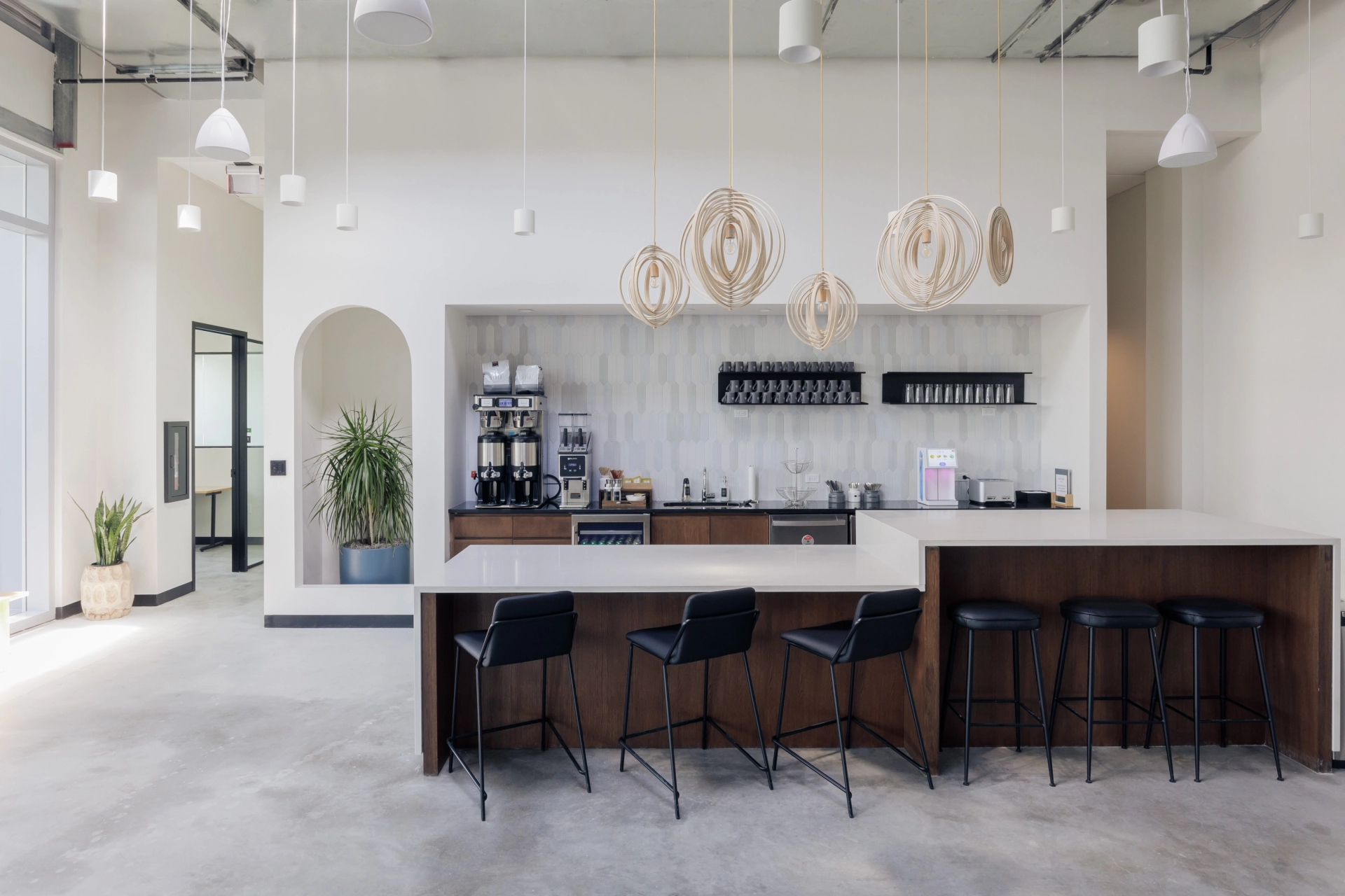 An open kitchen with stools serving as a workspace and a bar.