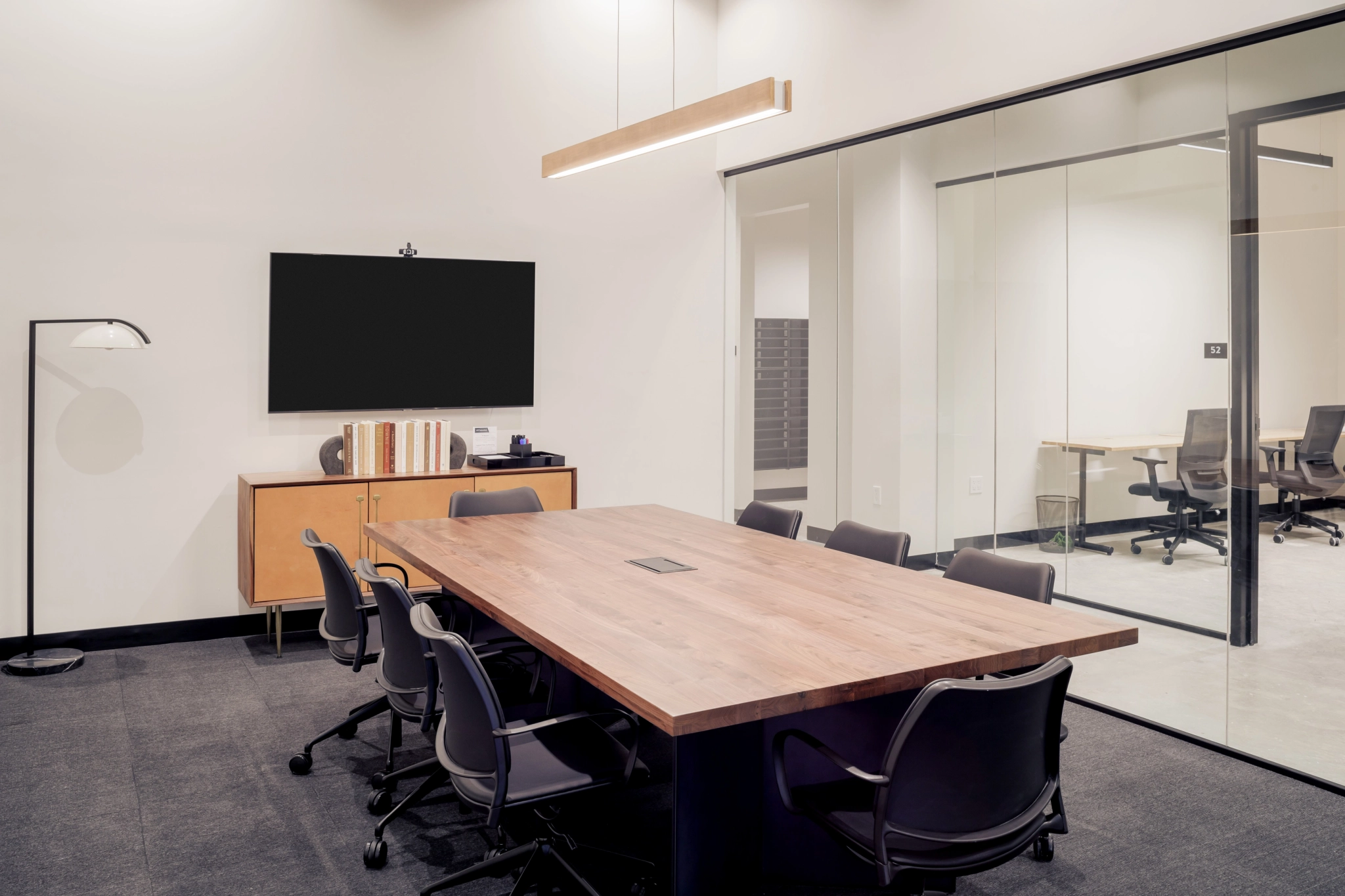 Una sala de reuniones con una mesa de madera.