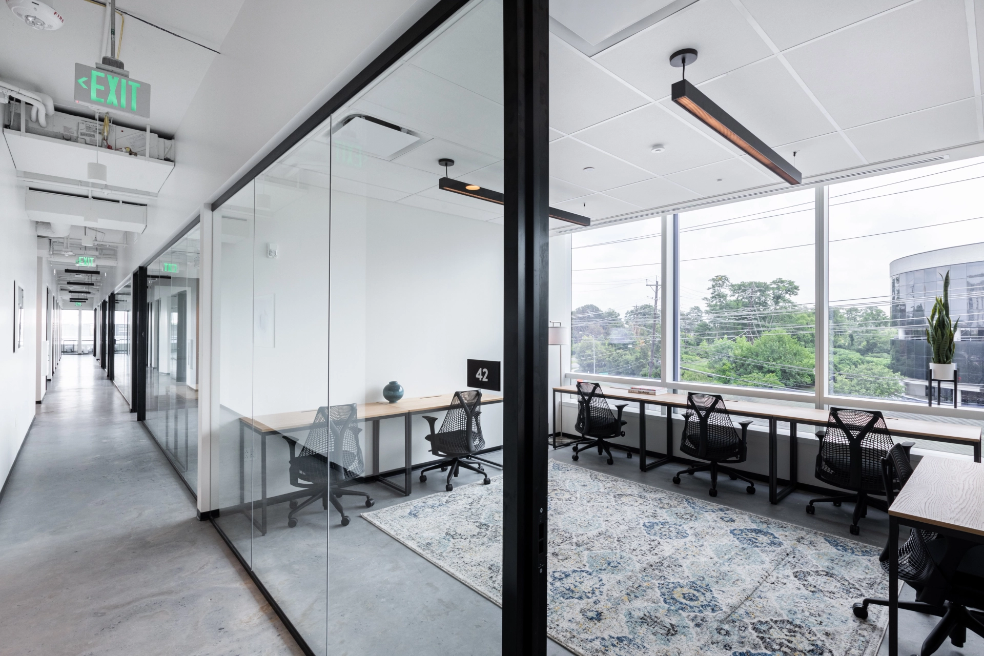 An open office with glass walls and desks, ideal for coworking.