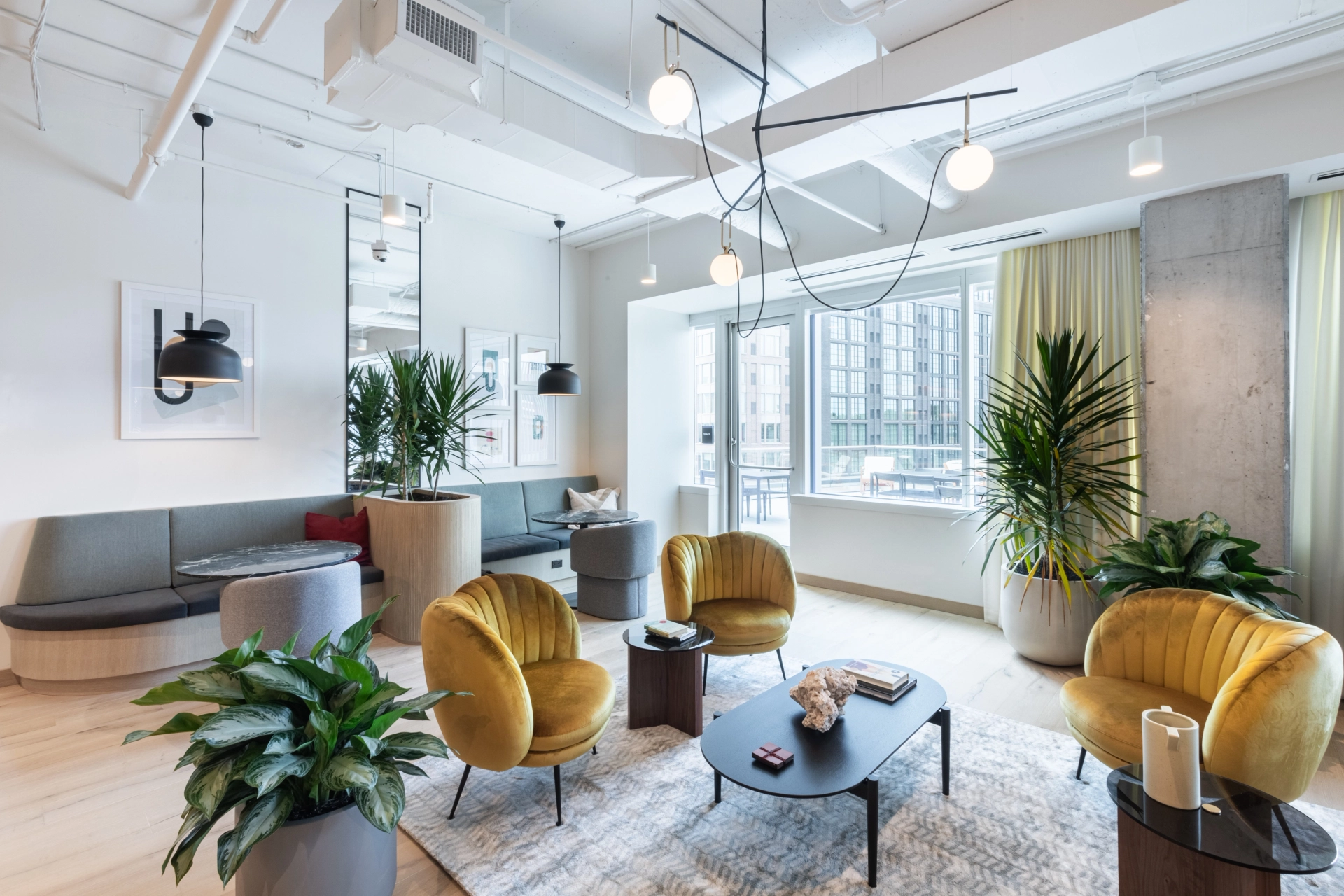 Un espace de coworking avec des chaises jaunes vibrantes et de nombreuses plantes pour favoriser un environnement de travail moderne.