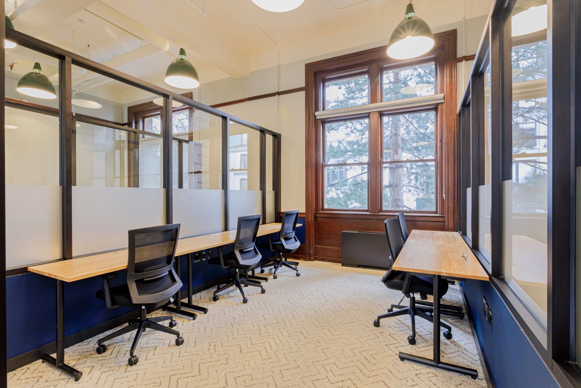 Un bureau de coworking à Portland avec des bureaux, des chaises et des fenêtres.