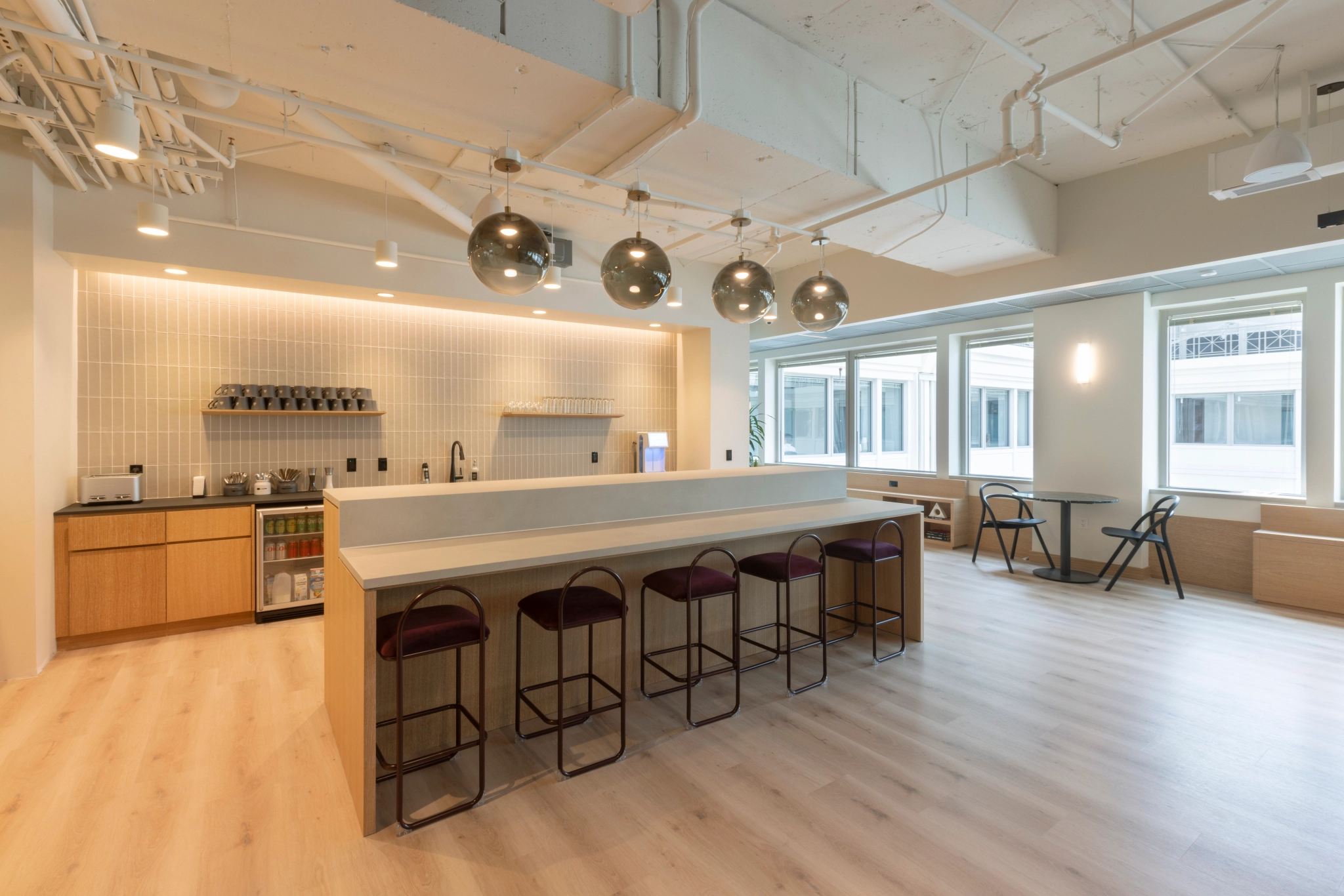 A coworking space in Washington with a large open office and a bar area with stools.