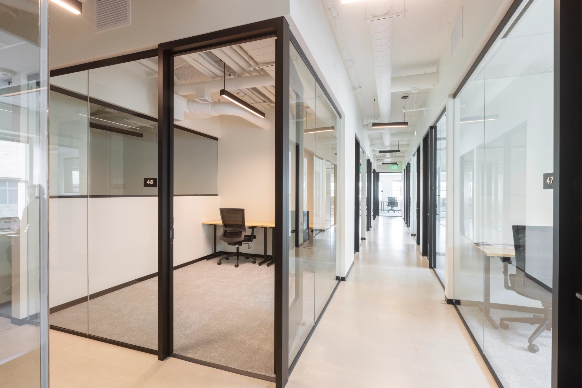 A Washington co-working workspace featuring glass walls and a desk.