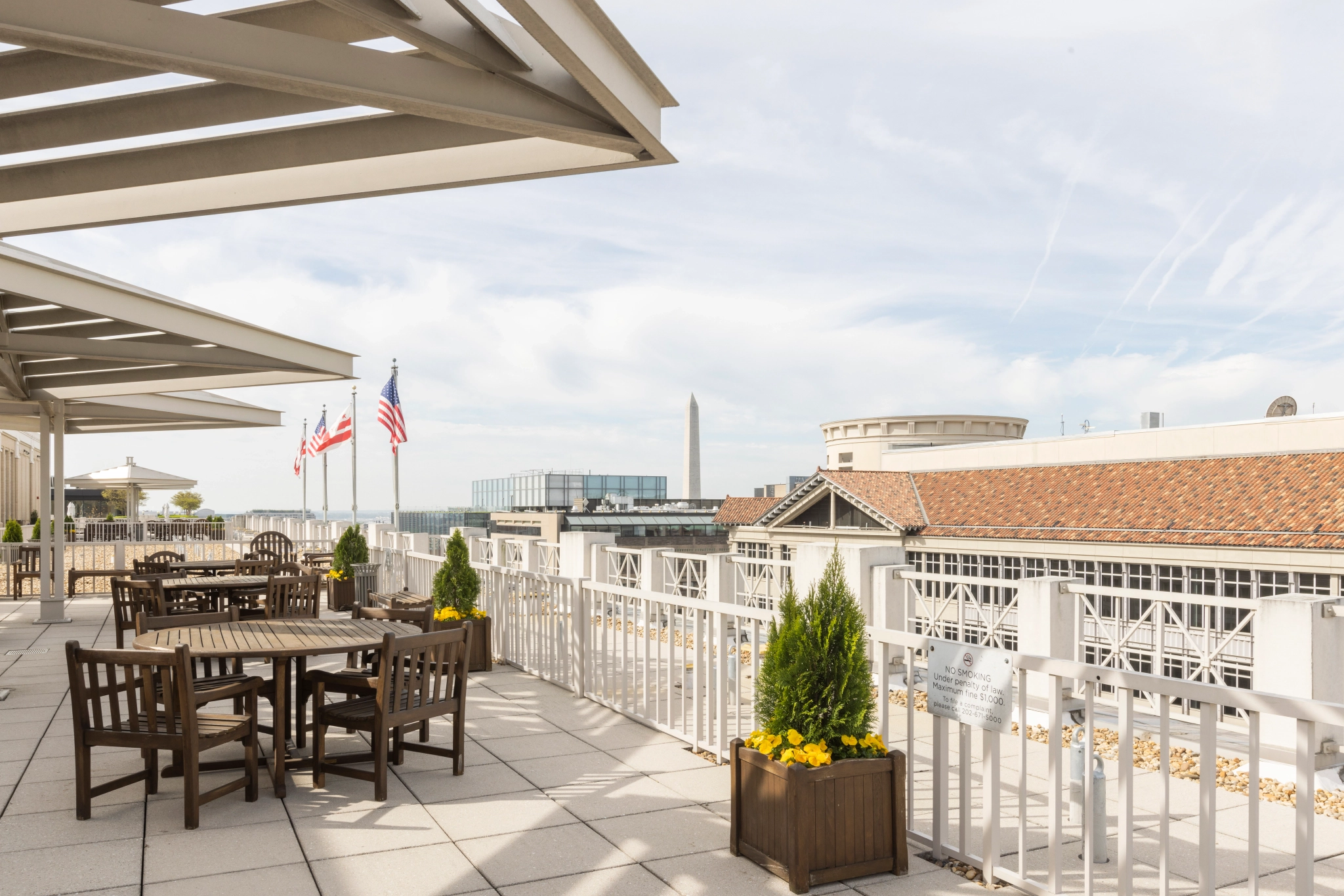 A coworking space with a balcony equipped with tables and chairs for meetings and office use.