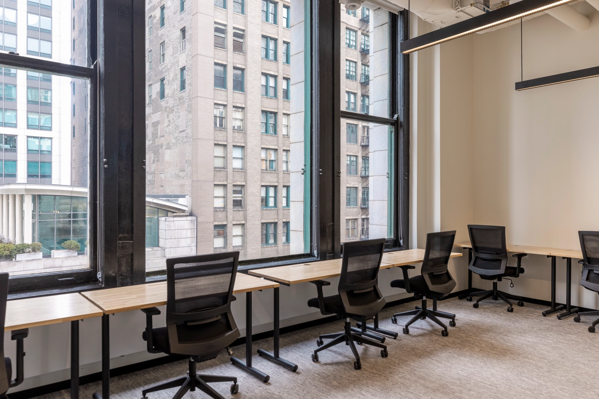 An office workspace in Chicago with desks and chairs in front of a large window.