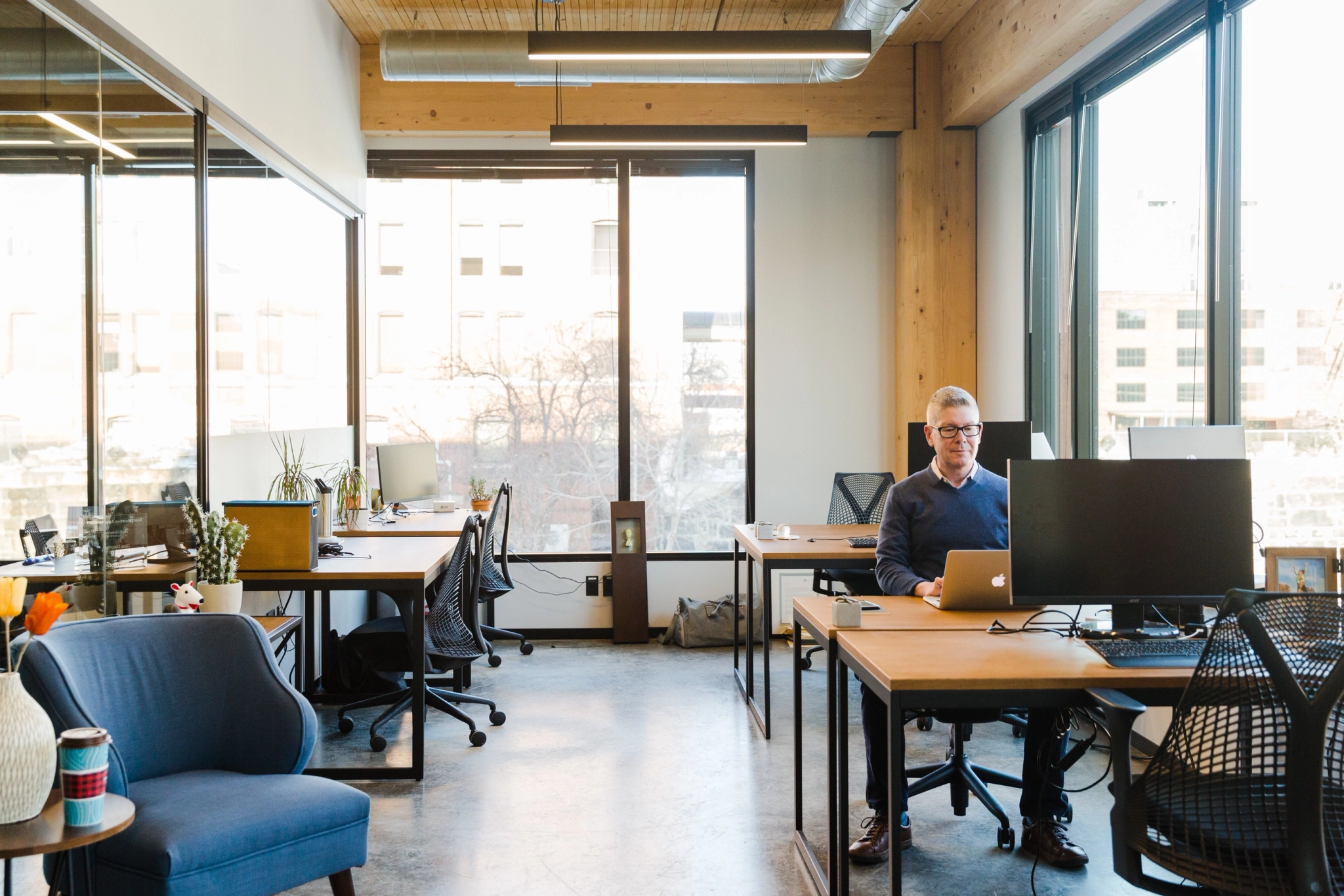 A man works at a coworking desk in an open office in Minneapolis.