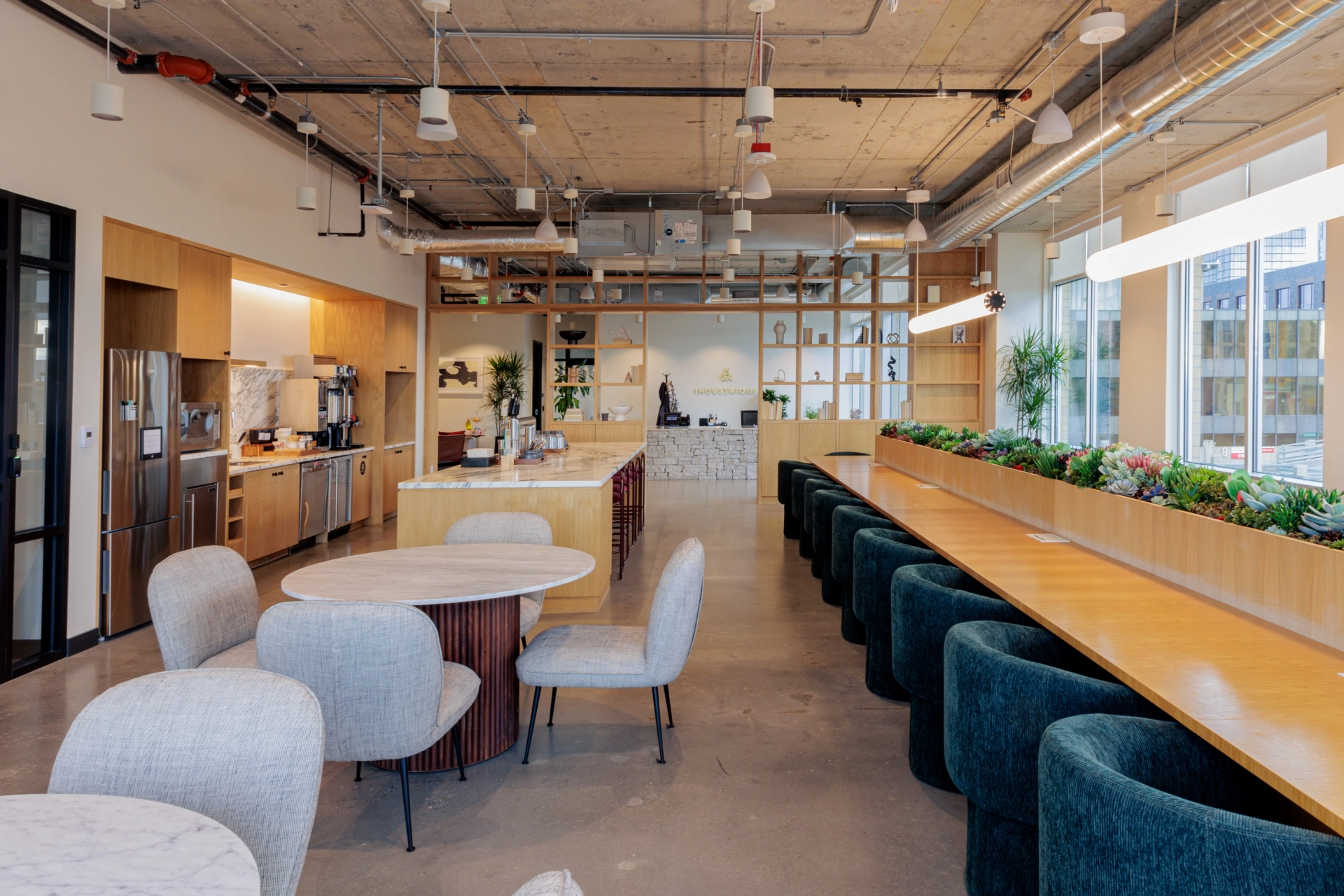 Moderne coworking-kantoorkeuken en gemeenschappelijke eetruimte met natuurlijk licht in Seattle.
