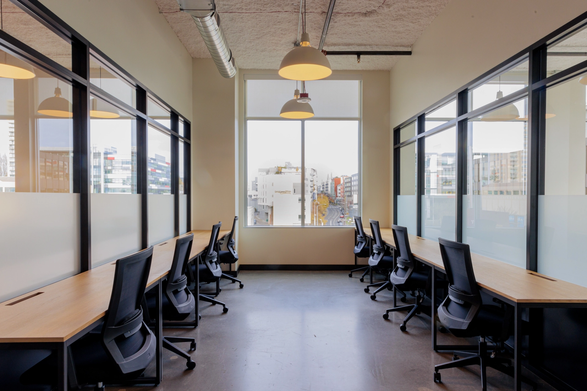 Moderne kantoorruimte met lege stoelen en tafels, met grote ramen met uitzicht op de stad, ontworpen voor coworking.