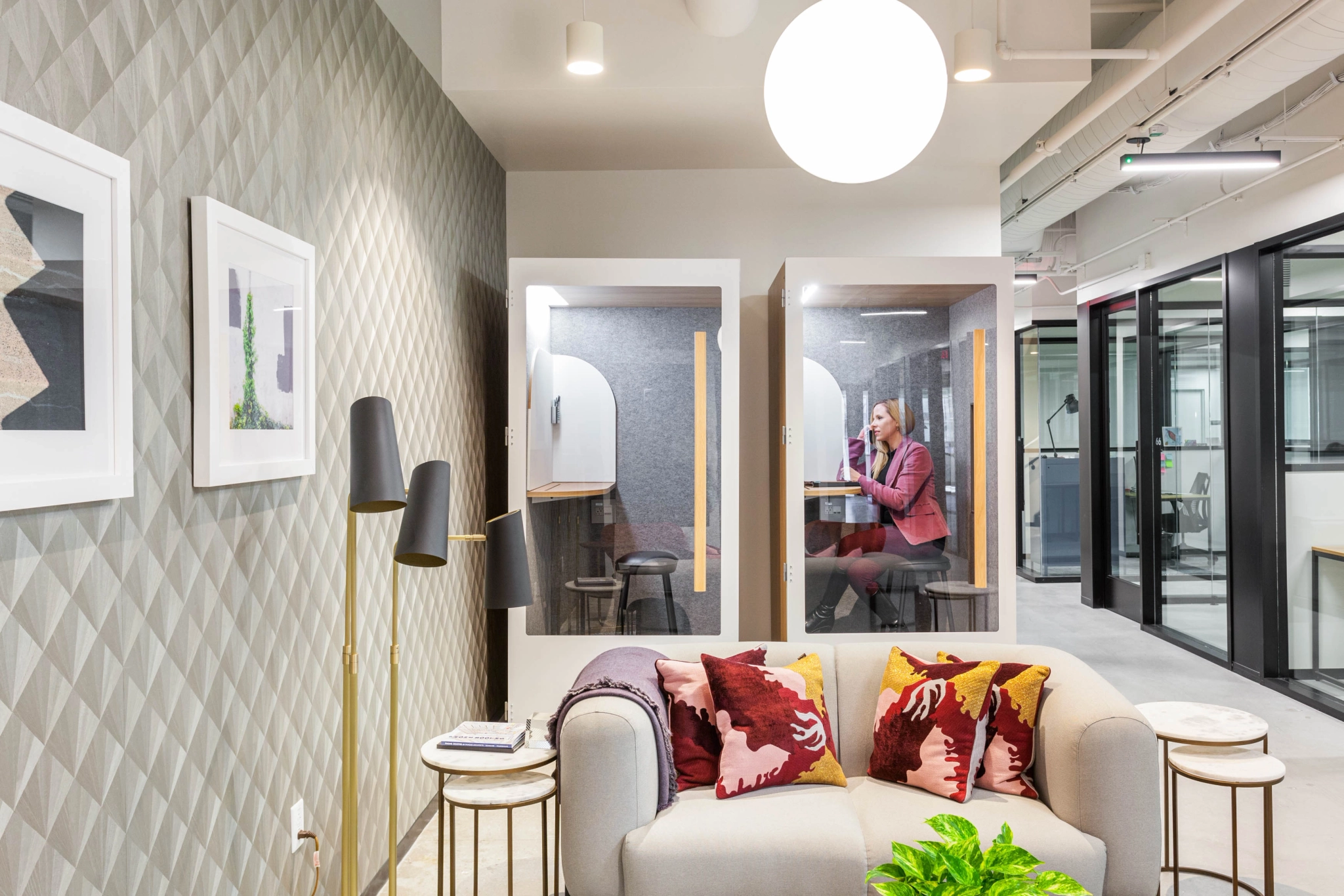 A coworking workspace in Irvine featuring a couch, chairs, and a wall of mirrors.