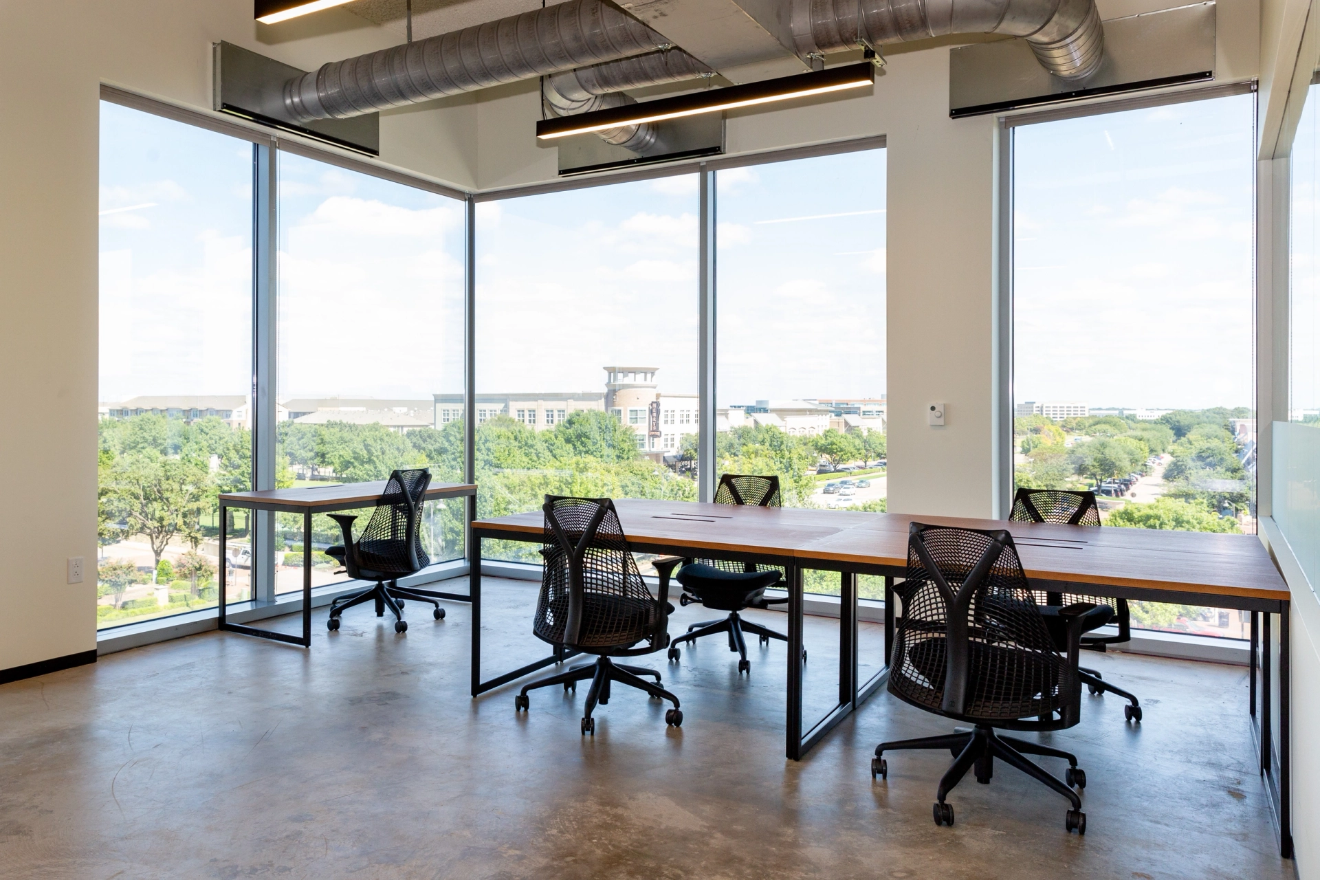 Un bureau de coworking Plano avec de grandes fenêtres et une vue imprenable sur la ville.