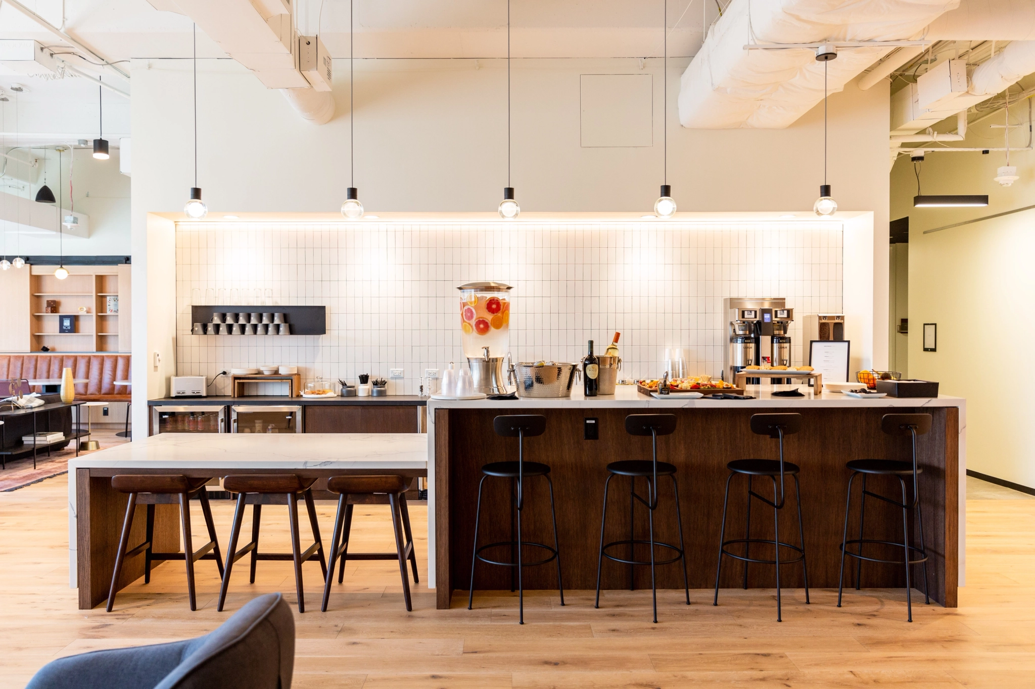 A coworking office with a kitchen and bar stools.