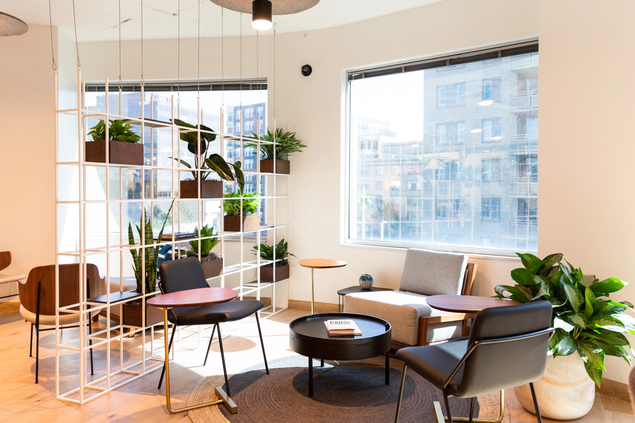 A coworking workspace with a table, chairs, and plants.