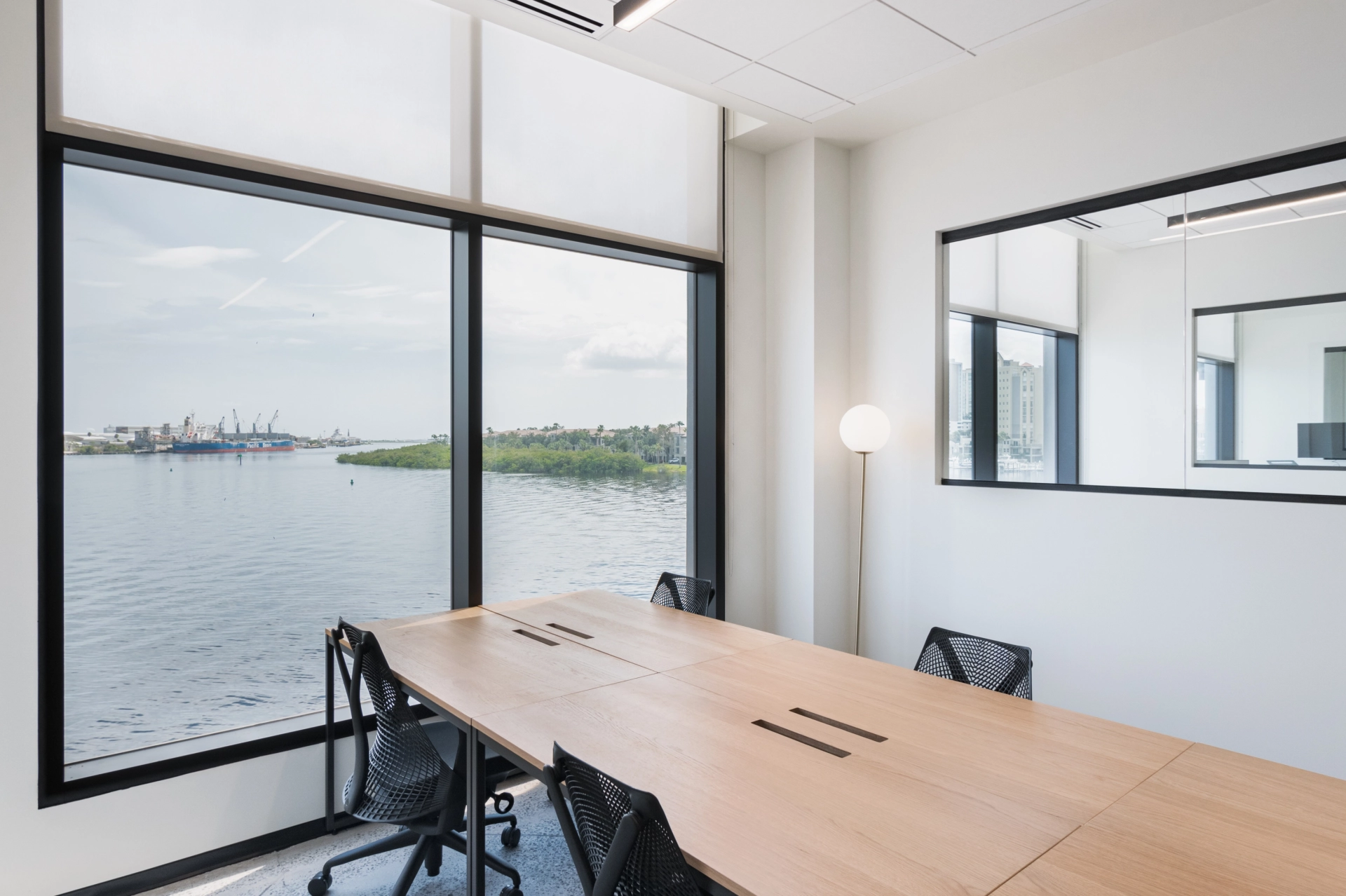 A waterfront meeting room with large windows.