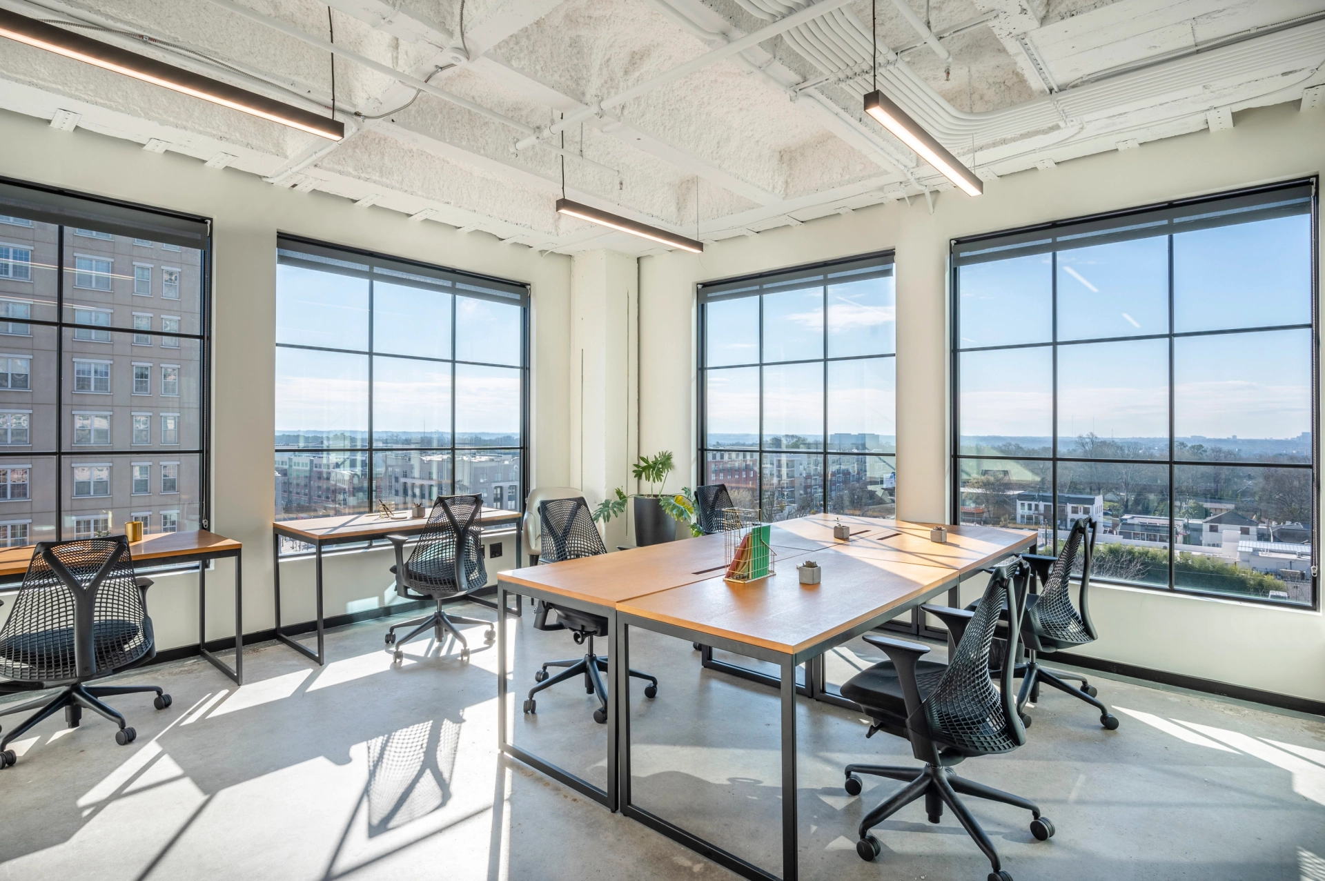 A coworking office with large windows overlooking a city.