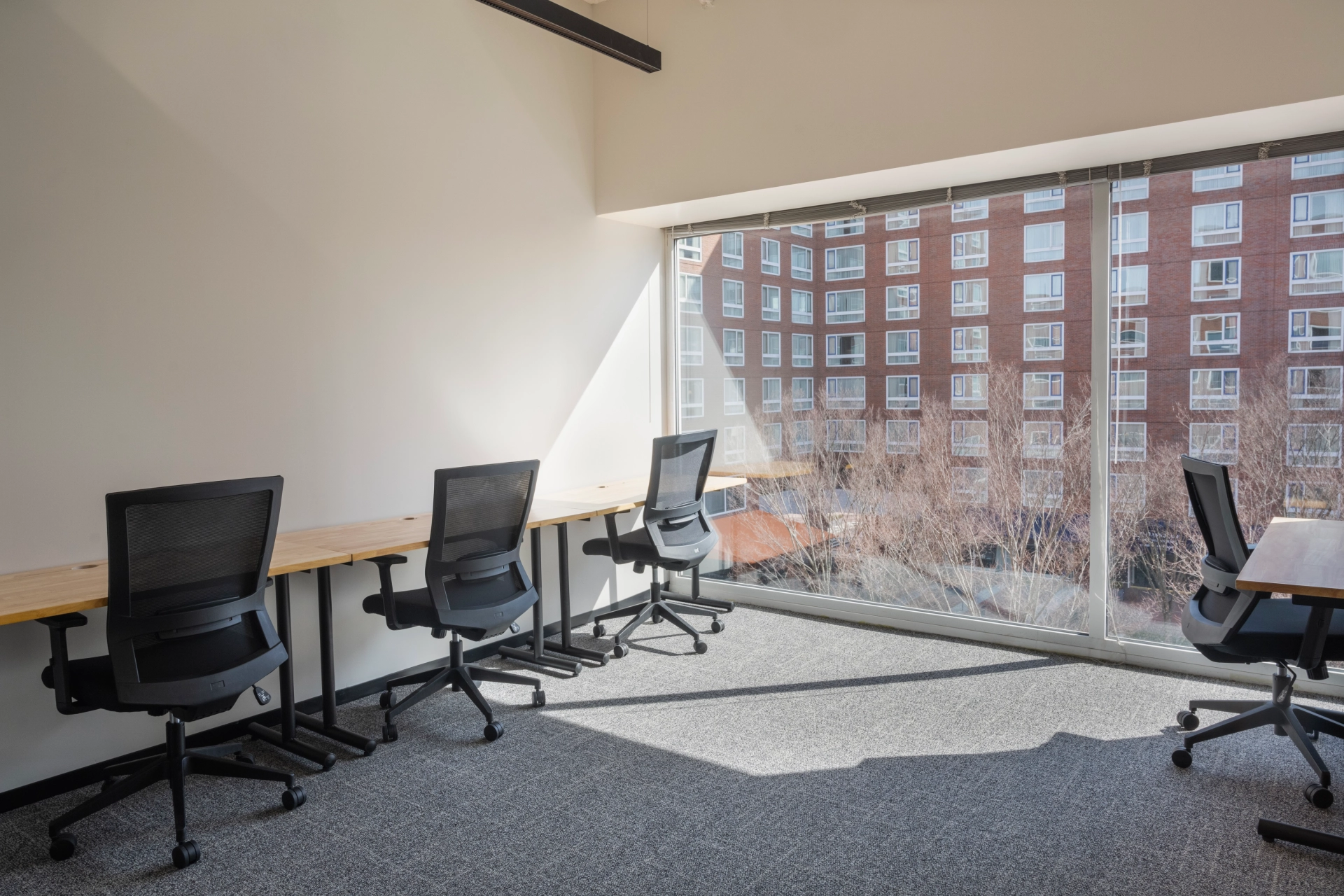 Un bureau de Cambridge vide avec des bureaux et des chaises devant une fenêtre.