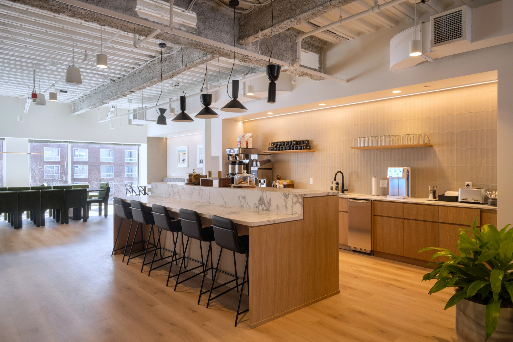 Un espace de travail de bureau avec une cuisine et un coin bar.