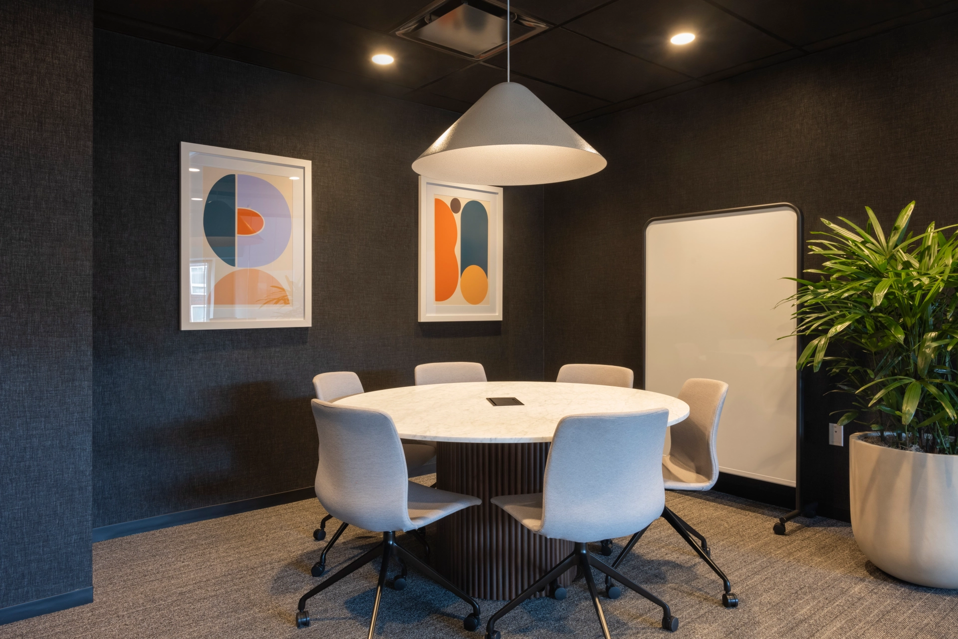 Een coworkingruimte uitgerust met een ronde tafel en stoelen, ideaal voor vergaderingen en samenwerkingen.