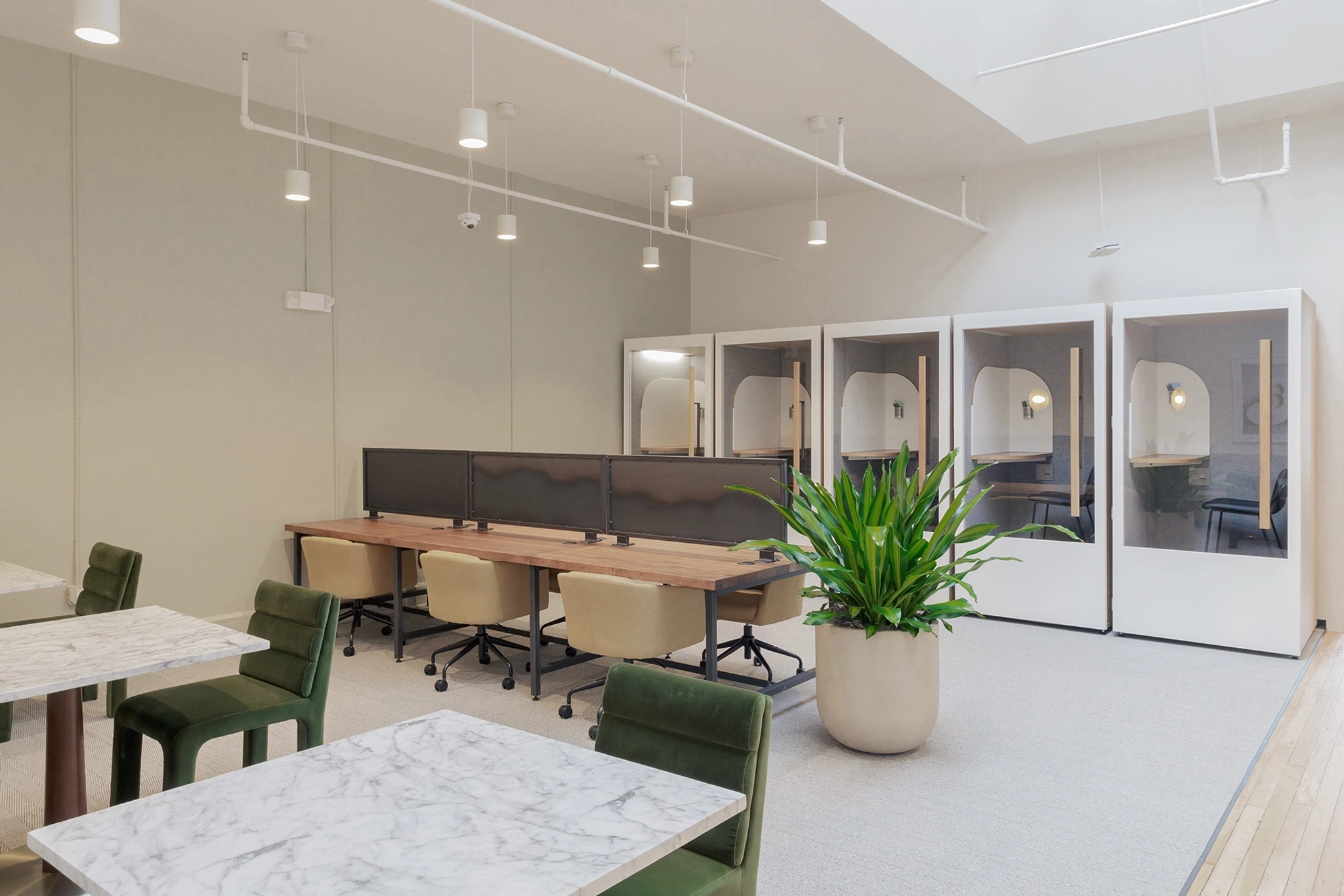 Un espace de travail blanc à New York avec des chaises et des tables vertes.