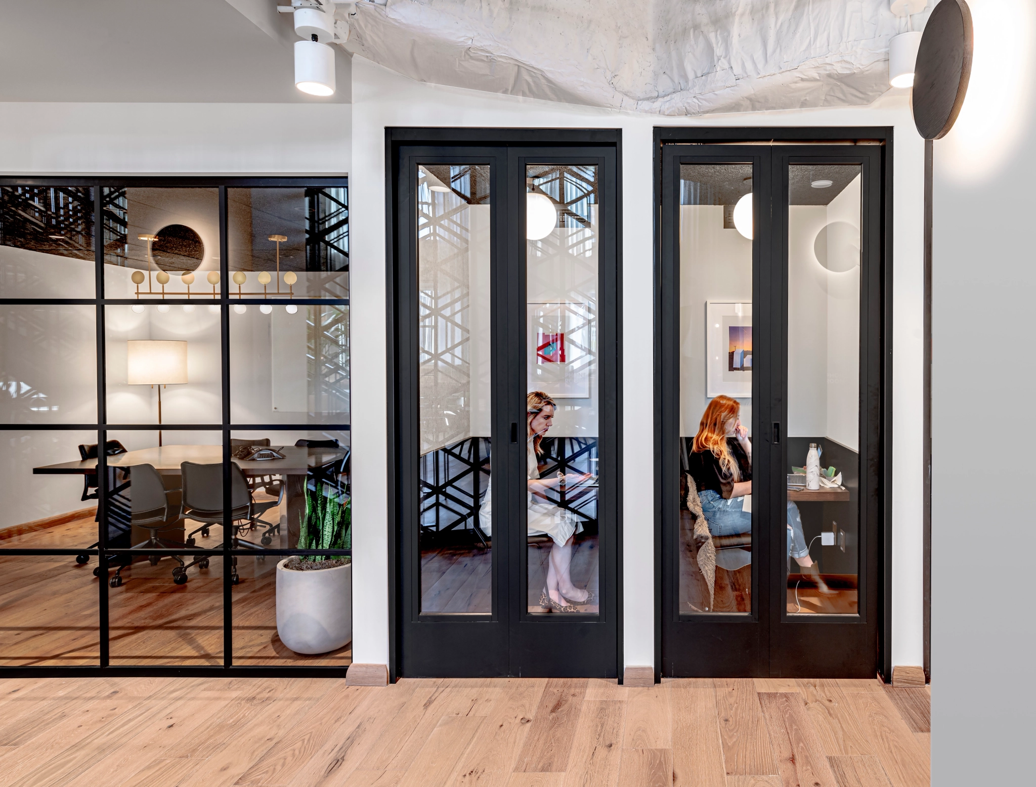 Two women are sitting in a Chicago office with glass doors.