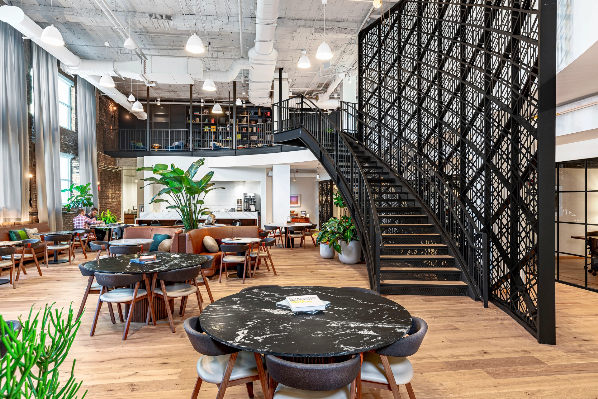 a Chicago restaurant with tables and chairs, featuring a spiral staircase.