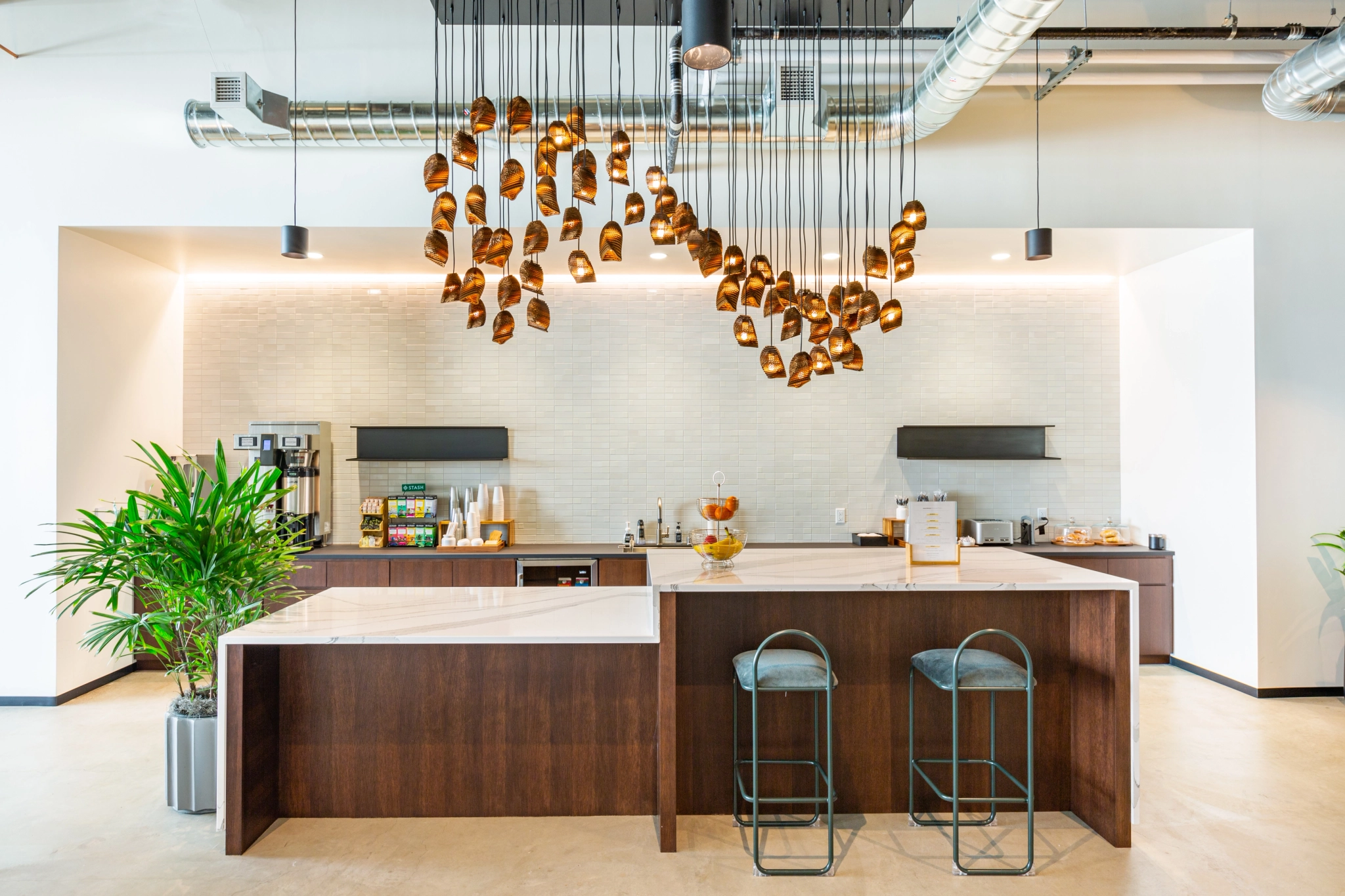 A modern Walnut Creek coworking meeting room with stools and a pendant light.