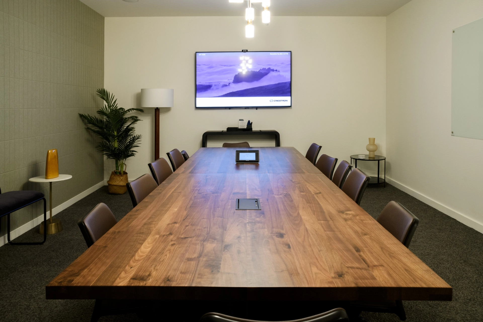 Un espace de coworking à Los Angeles équipé d'une grande table en bois et d'une TV pour des réunions ou des présentations.