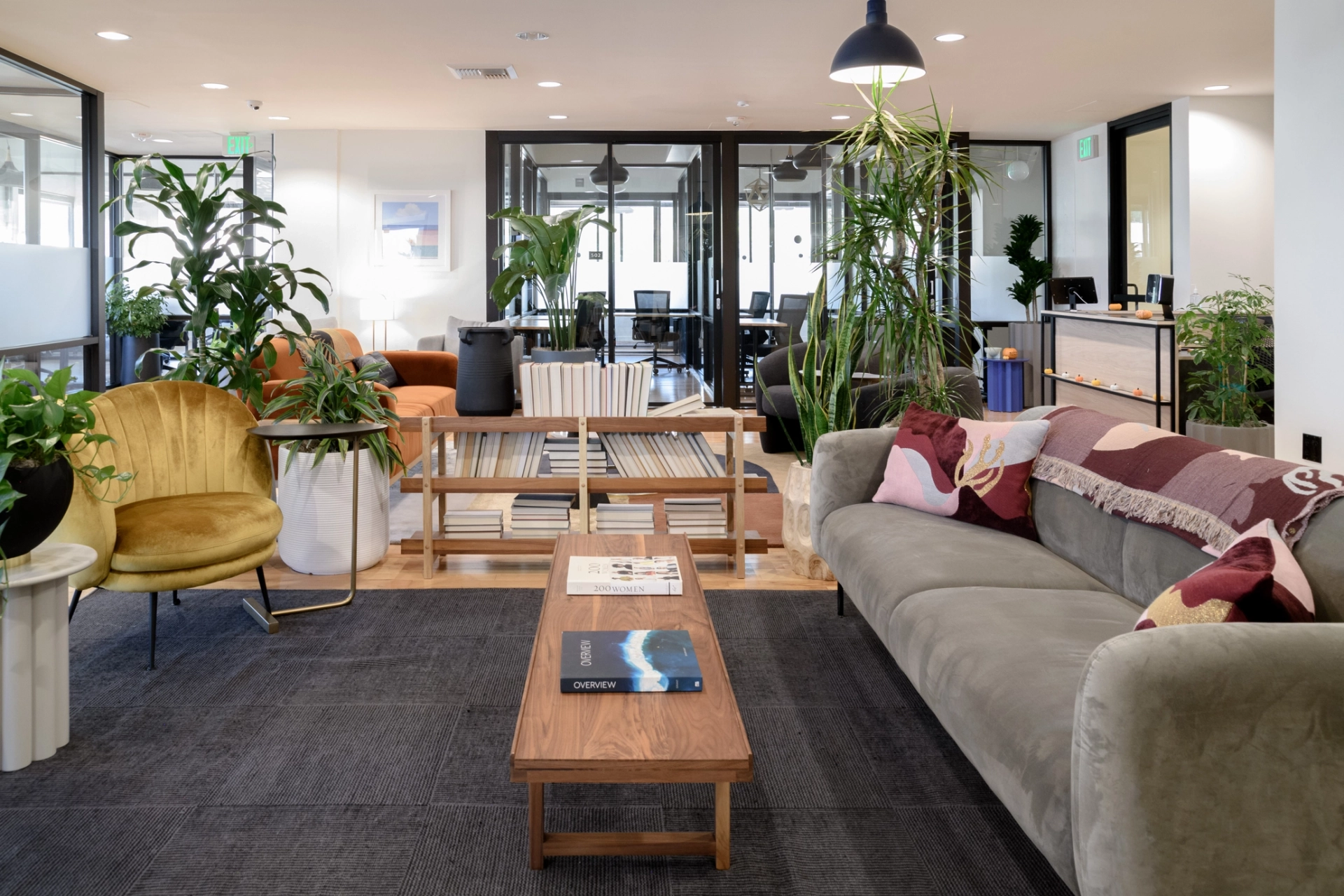 Moderne coworking-kantoorlounge in Los Angeles met comfortabele stoelen en kamerplanten.