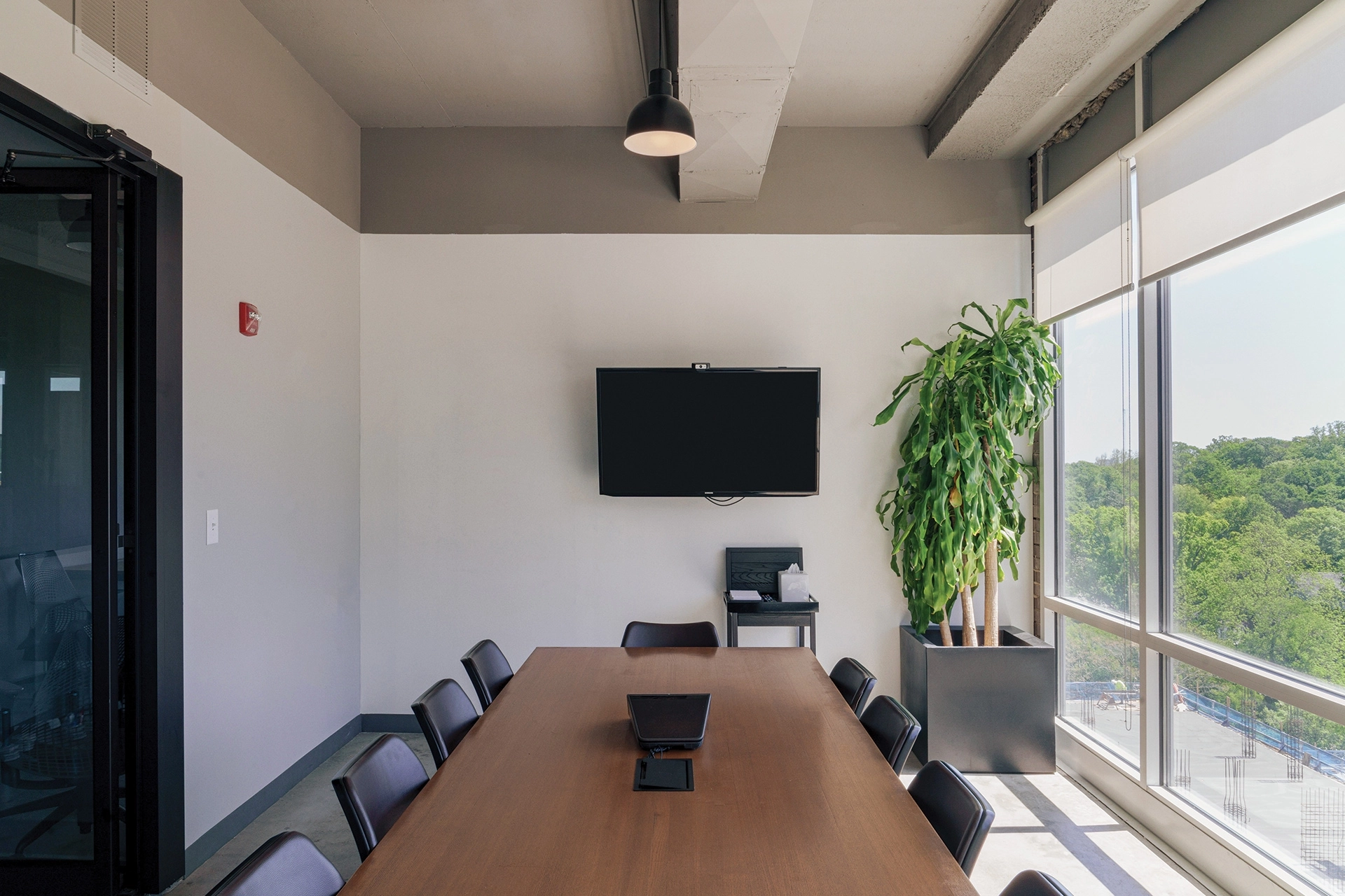Une salle de réunion de coworking équipée d'une table, de chaises et d'une grande fenêtre.