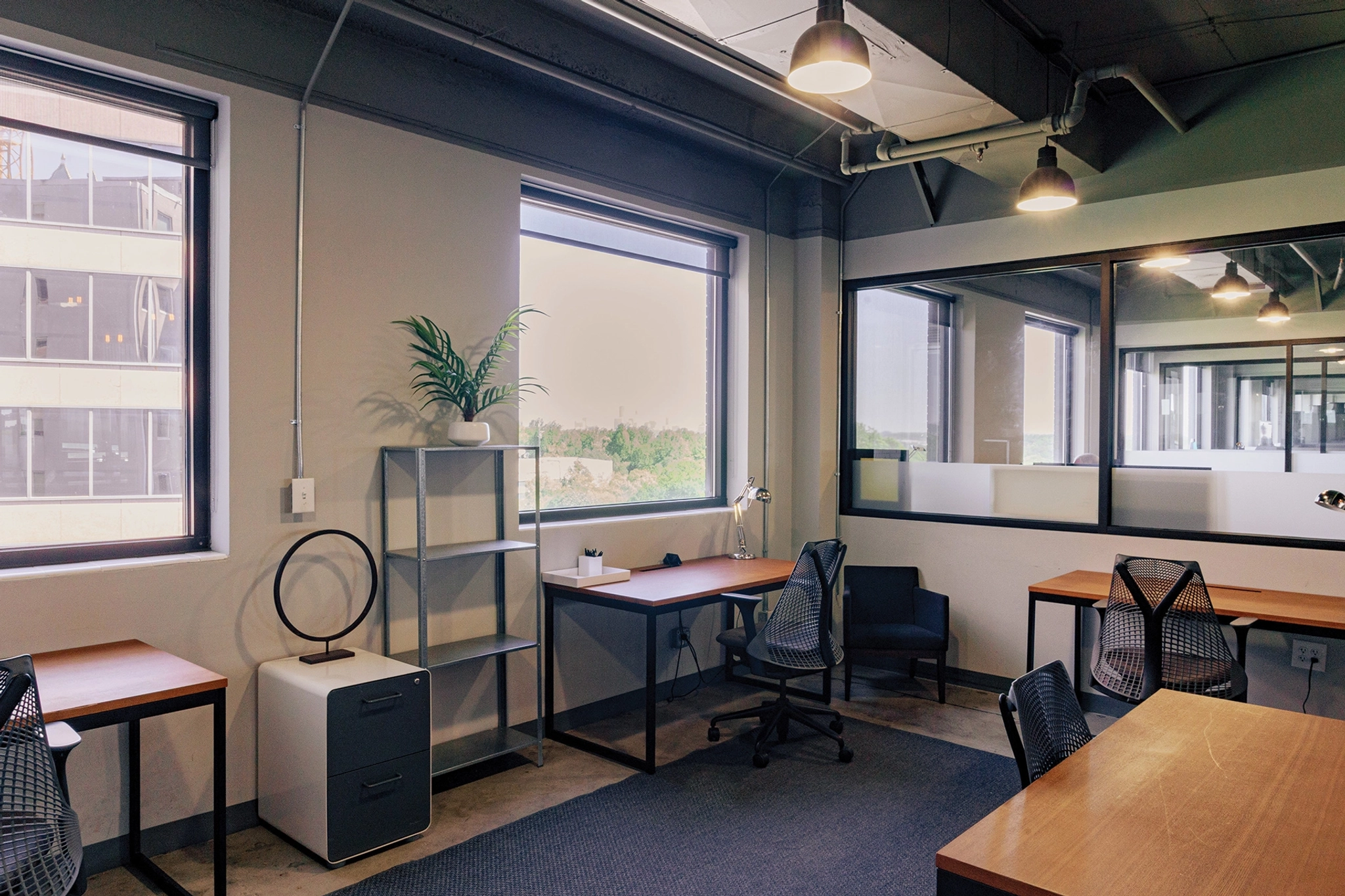 An office workspace with desks, chairs and a window.