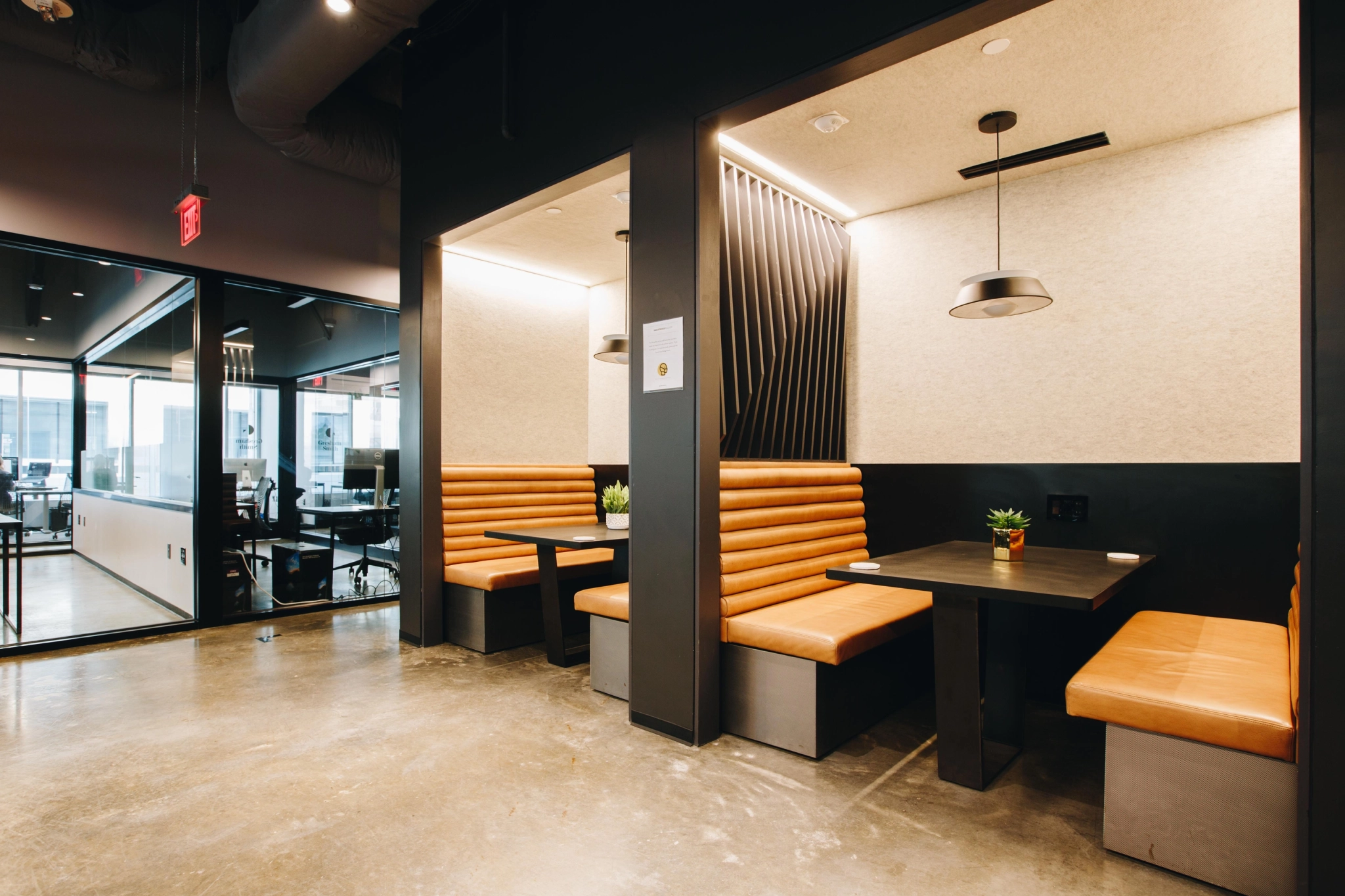 An office in Raleigh featuring black and orange booths and tables for meetings.