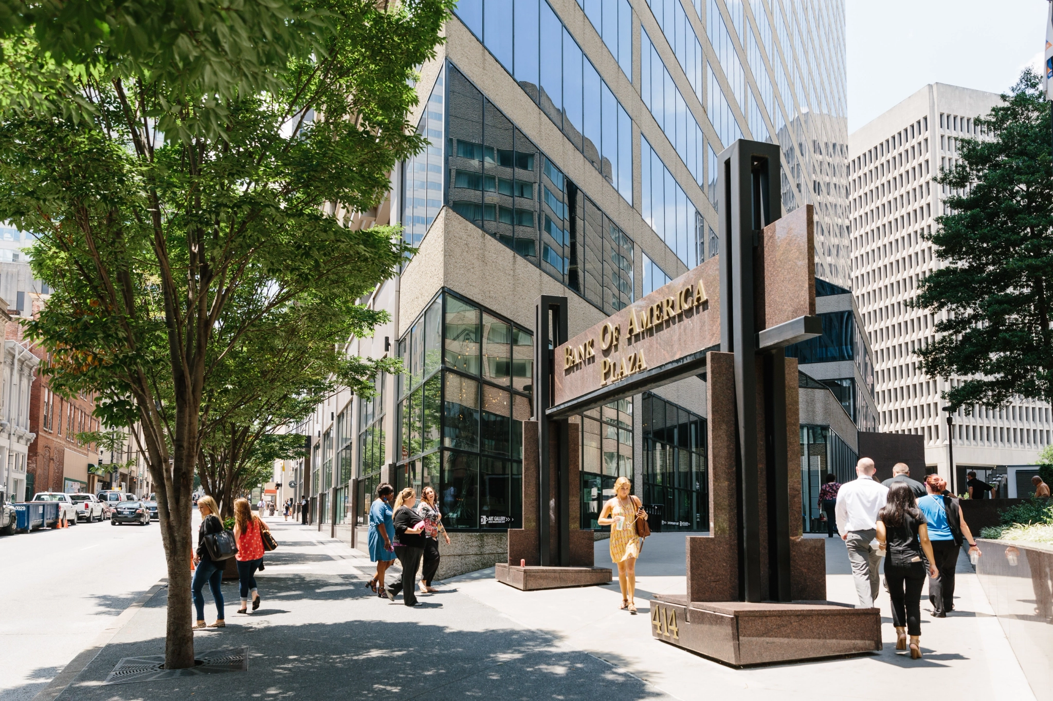 a group of people walking down a sidewalk in front of an office building in Nashville.