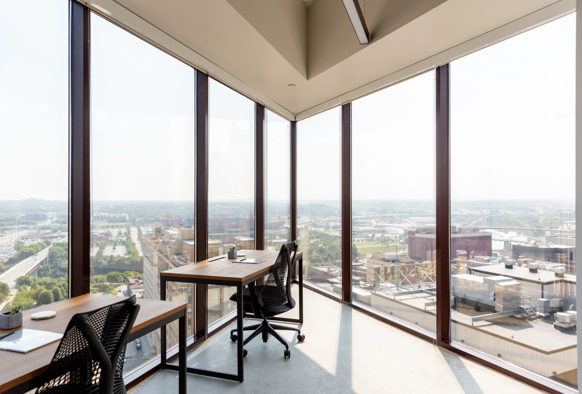 A coworking office with large windows overlooking a city.