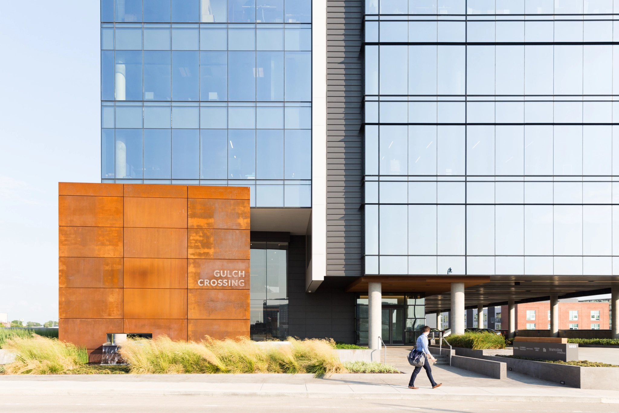 A man walks past a large office building in Nashville.