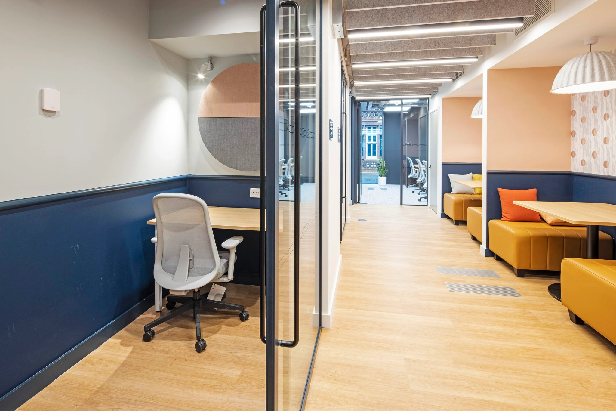 Un espace de travail de bureau à Manchester avec un bureau et des chaises dans le couloir.