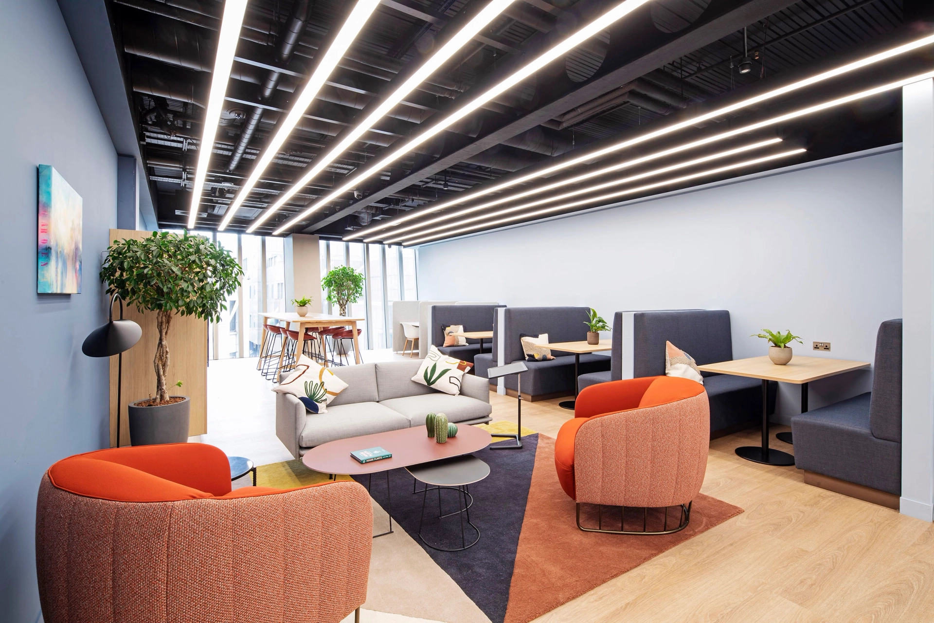 Un bureau de coworking moderne à Londres avec des chaises et des tables orange.