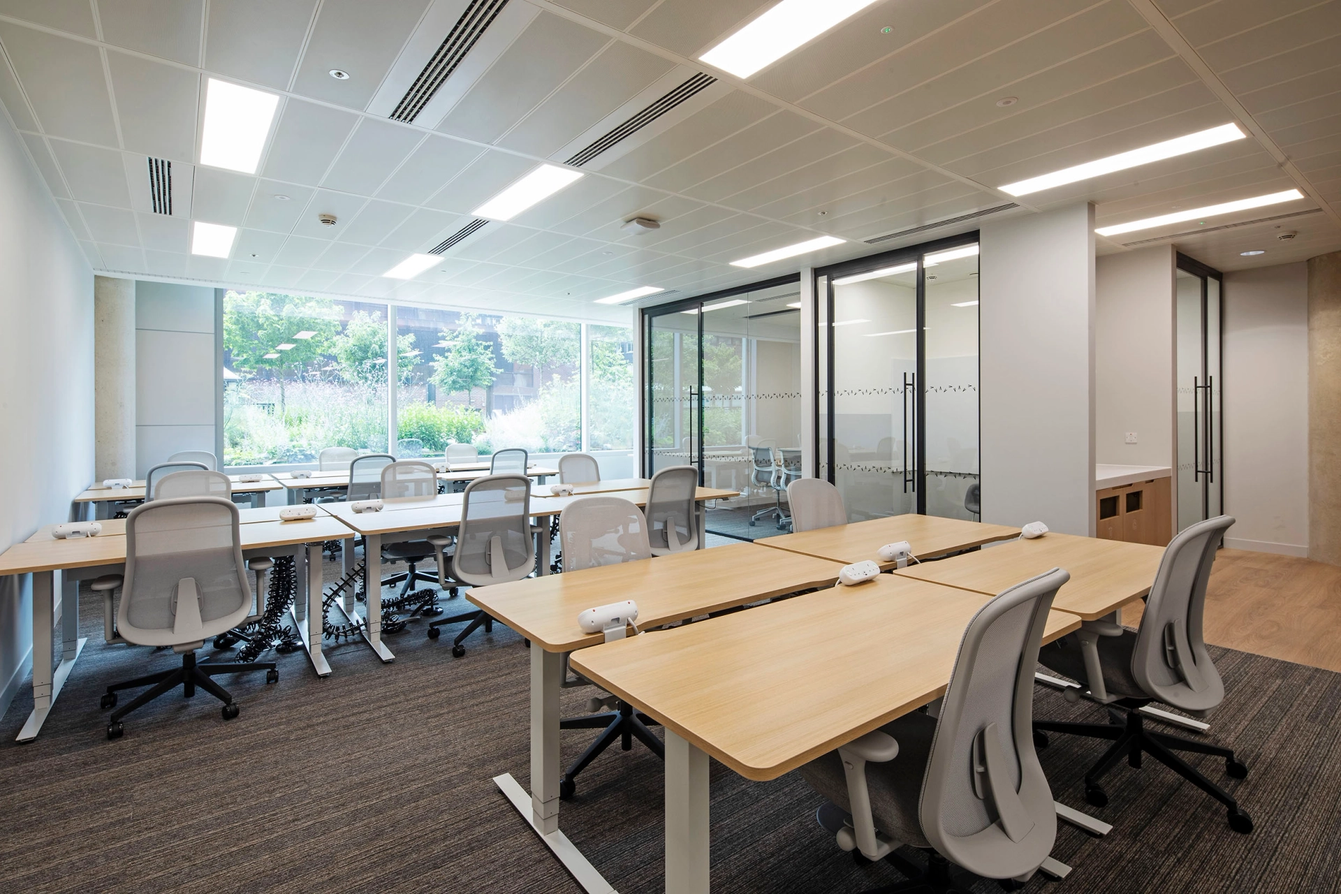 Un espace de coworking spacieux à Londres meublé de tables et de chaises pour les conférences.