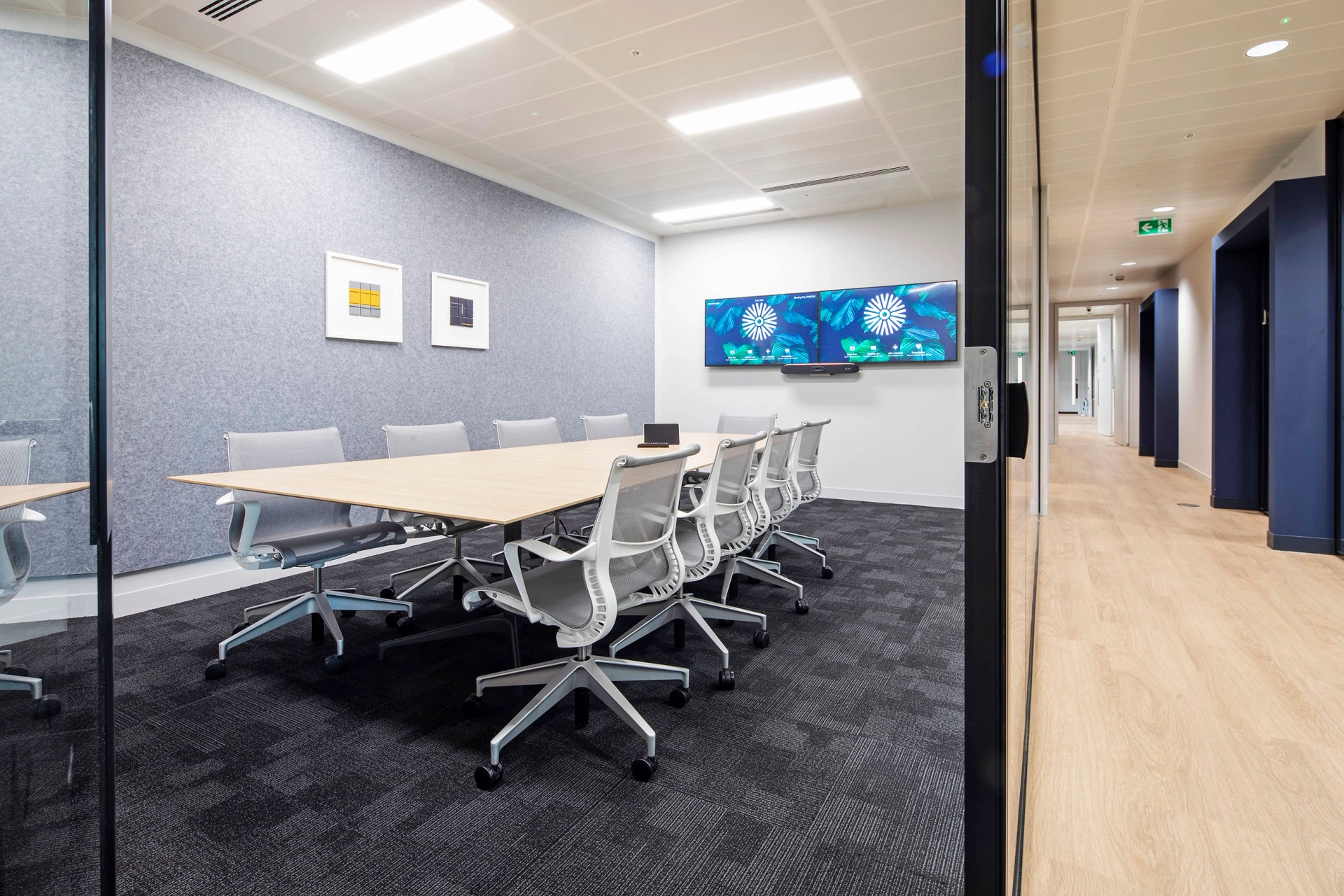 Une salle de conférence de bureau à Londres, avec un mur de verre et des chaises.