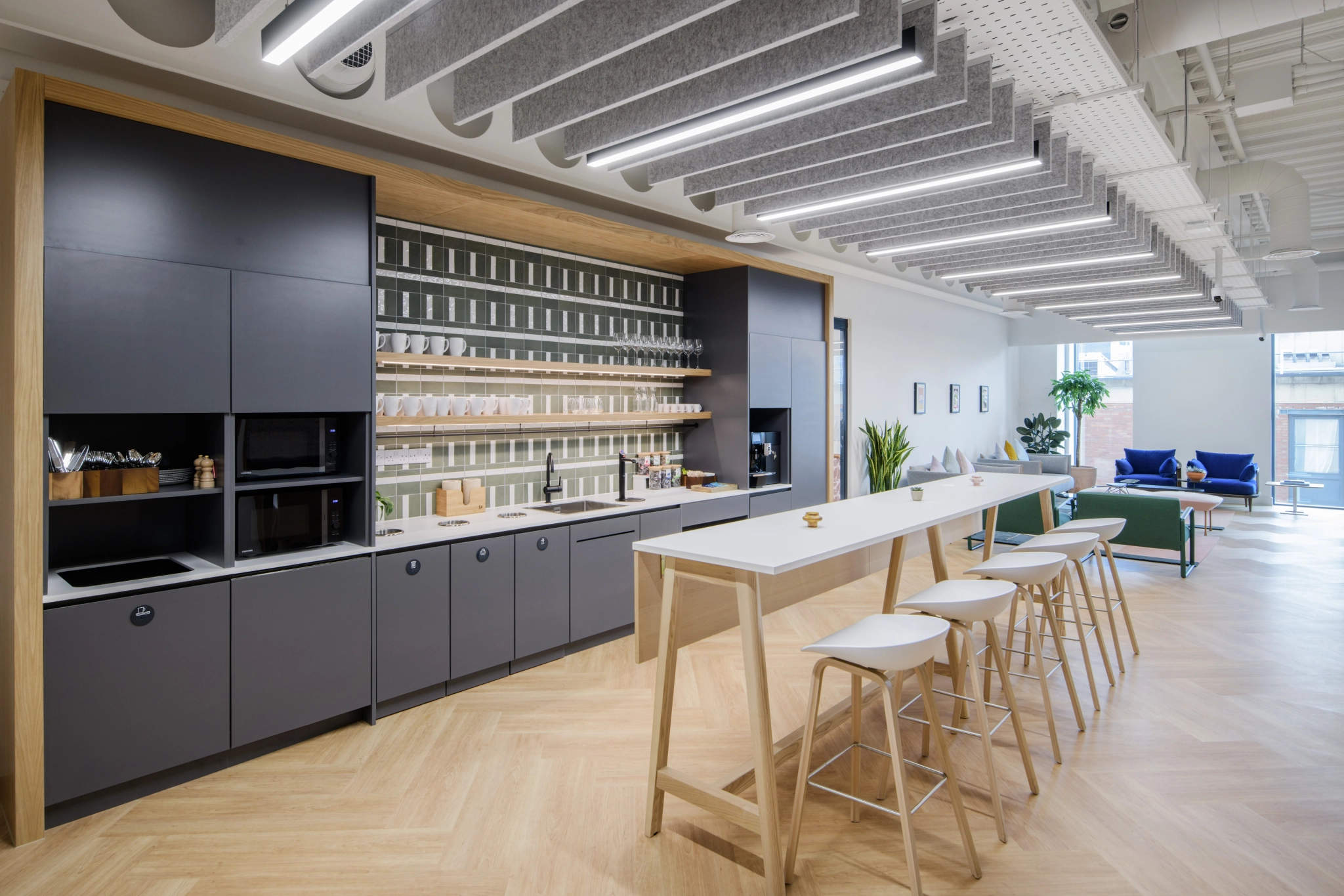 Un espace de coworking moderne avec un bar et des tabourets.