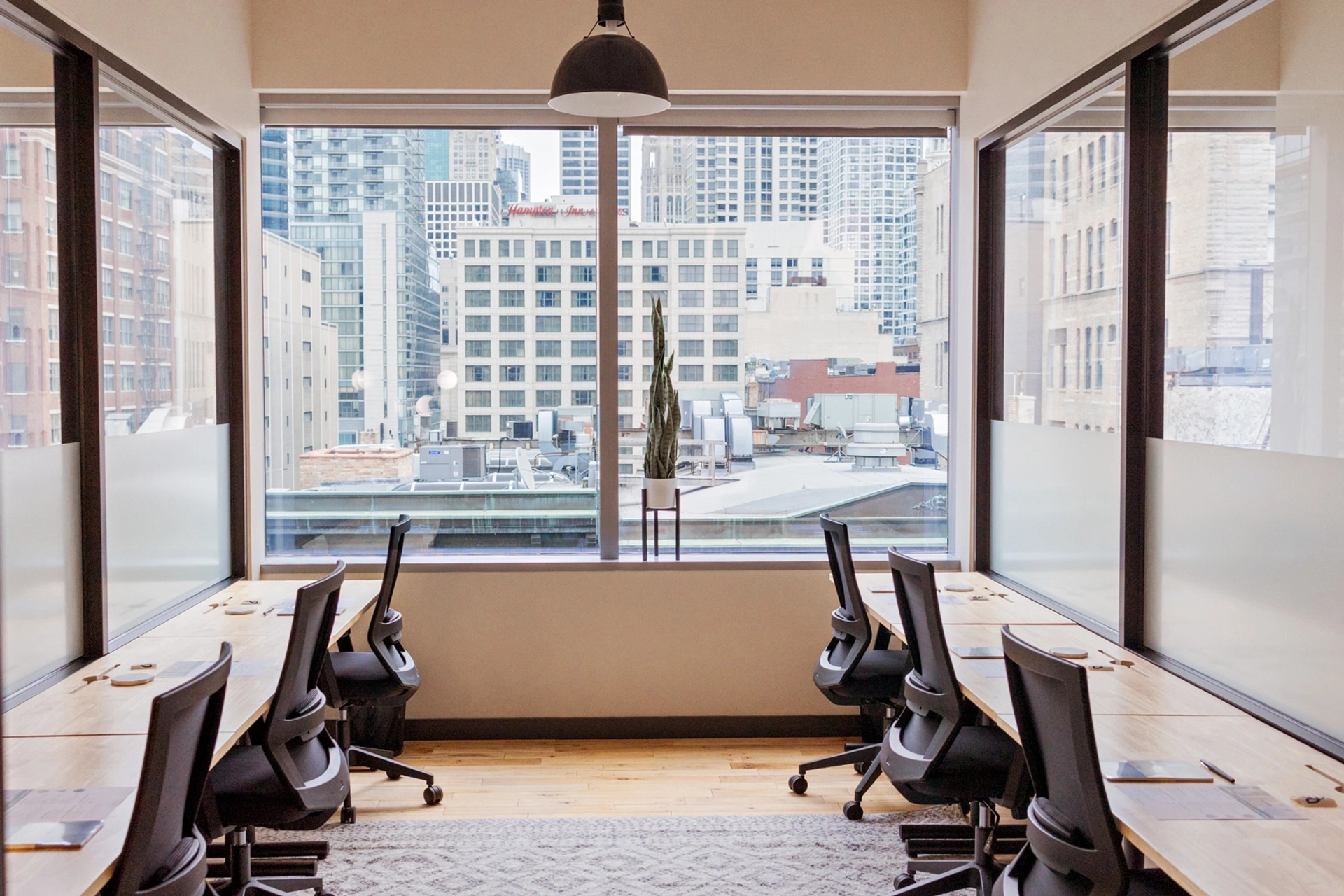 A spacious office with desks and a breathtaking view of the city.