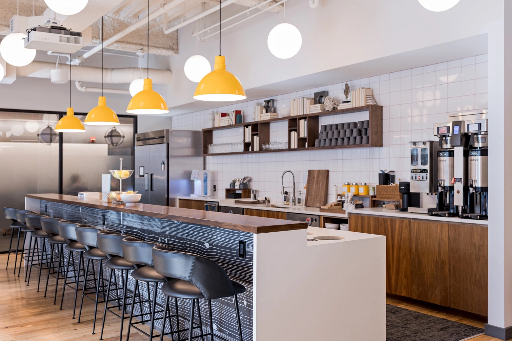 an open kitchen with stools in a workspace.