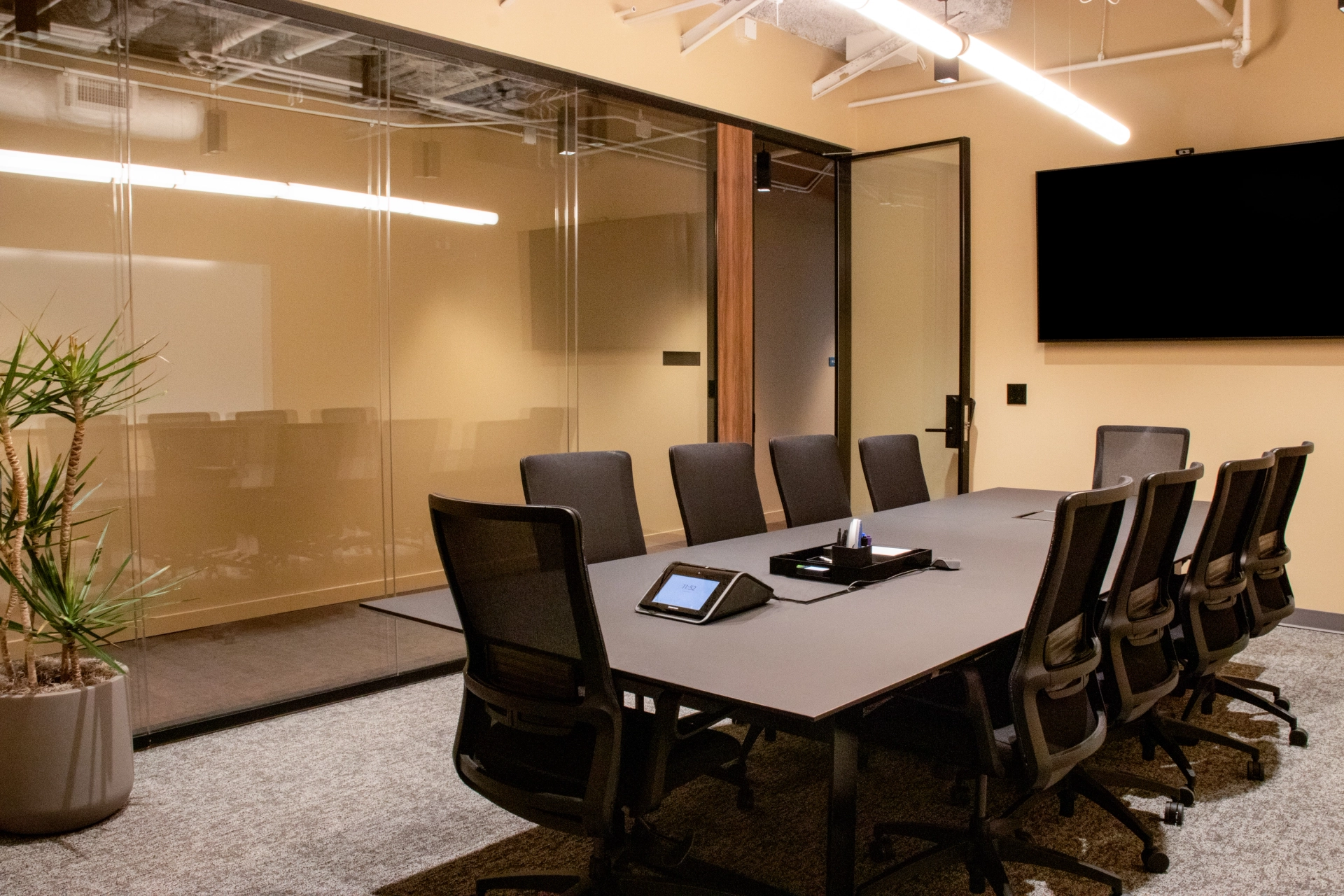 Une salle de réunion de coworking à Atlanta, avec un mur de verre et des chaises.