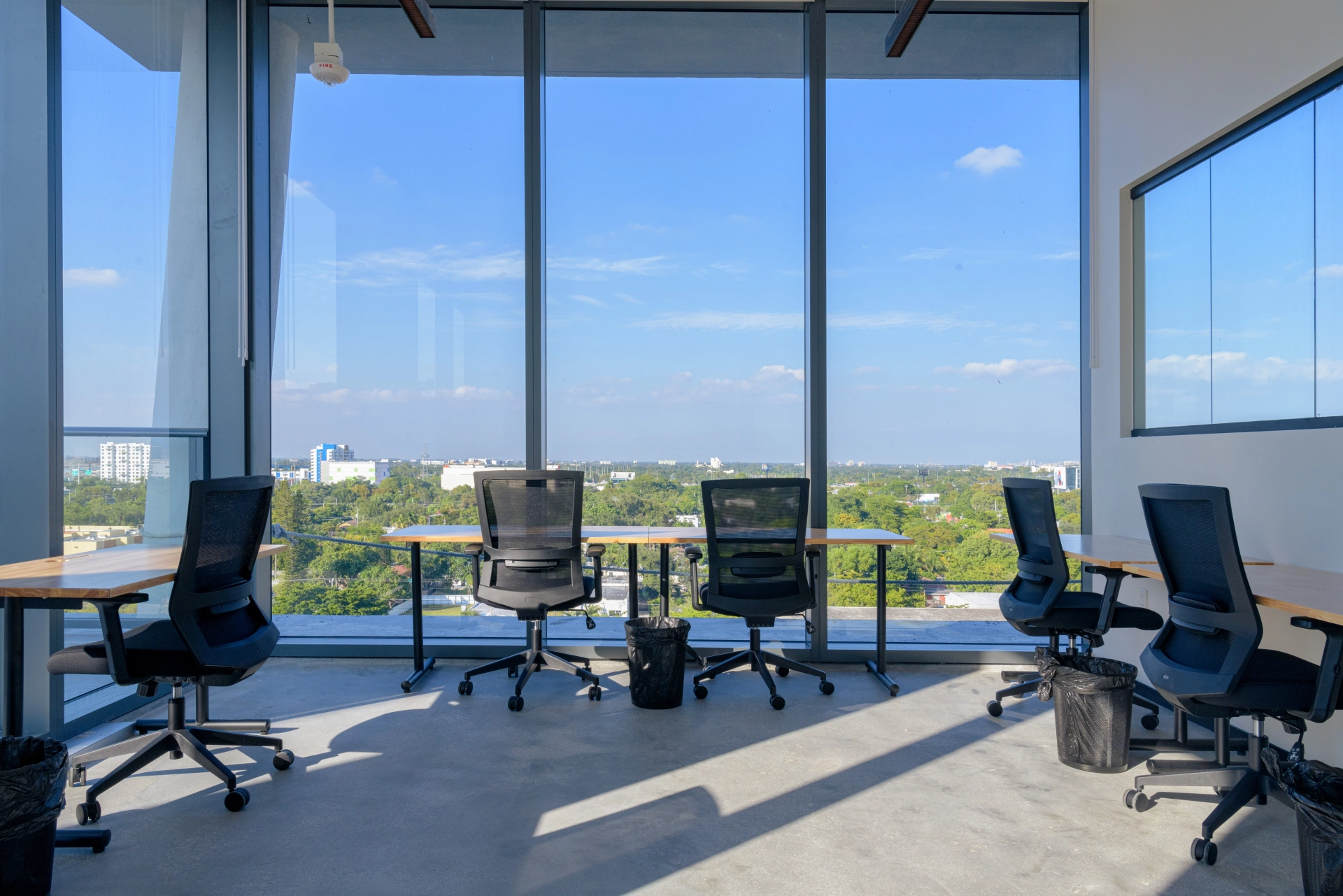 a large Miami coworking meeting room with desks and chairs and a view of the city.